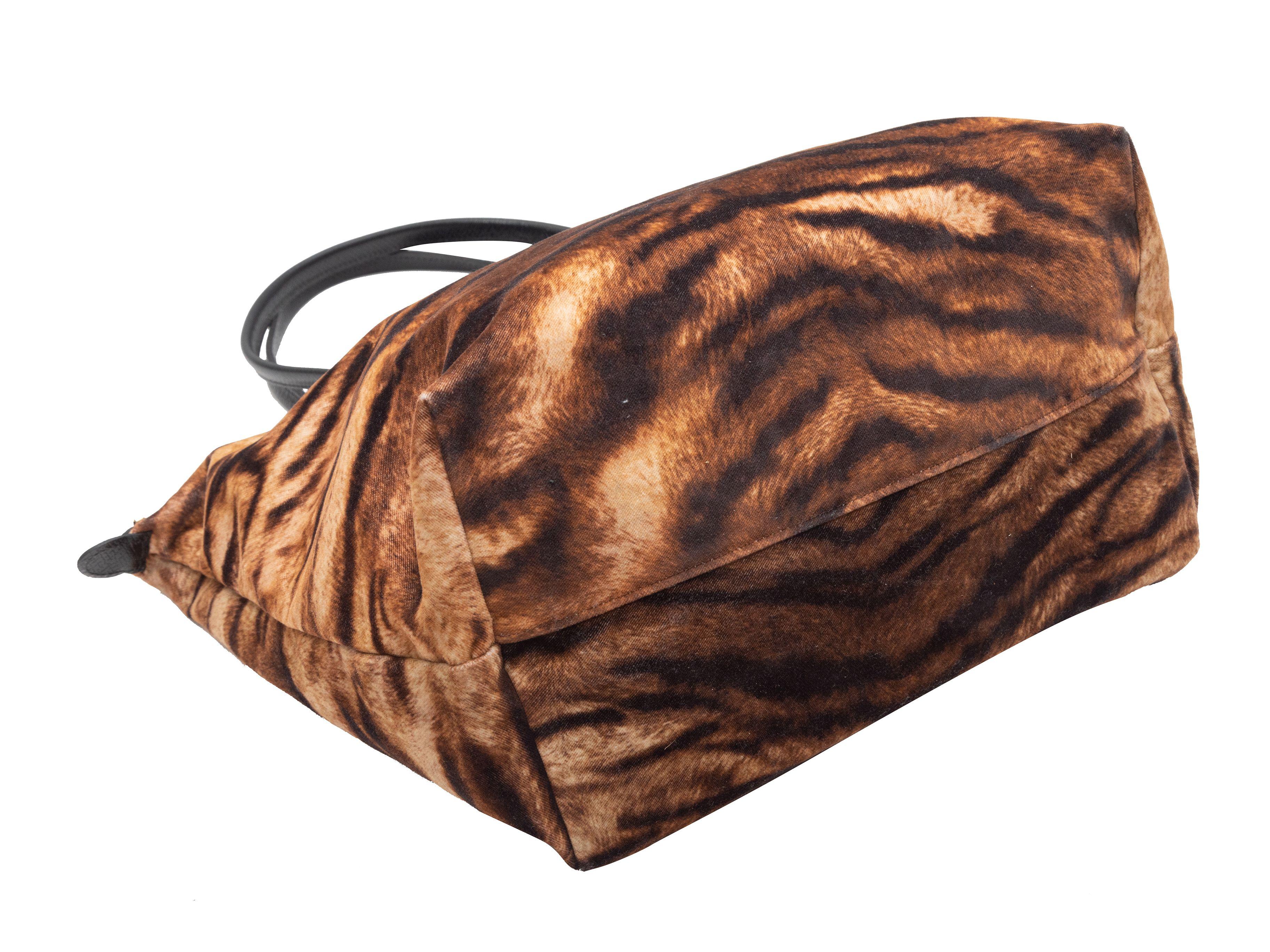 Détails du produit : Fourre-tout Longchamp marron en velours imprimé tigre Le Pliage. Le fourre-tout Pliage est doté d'un corps en velours, d'une quincaillerie en métal doré, d'une double bandoulière roulée et d'une fermeture à bouton-pression sur