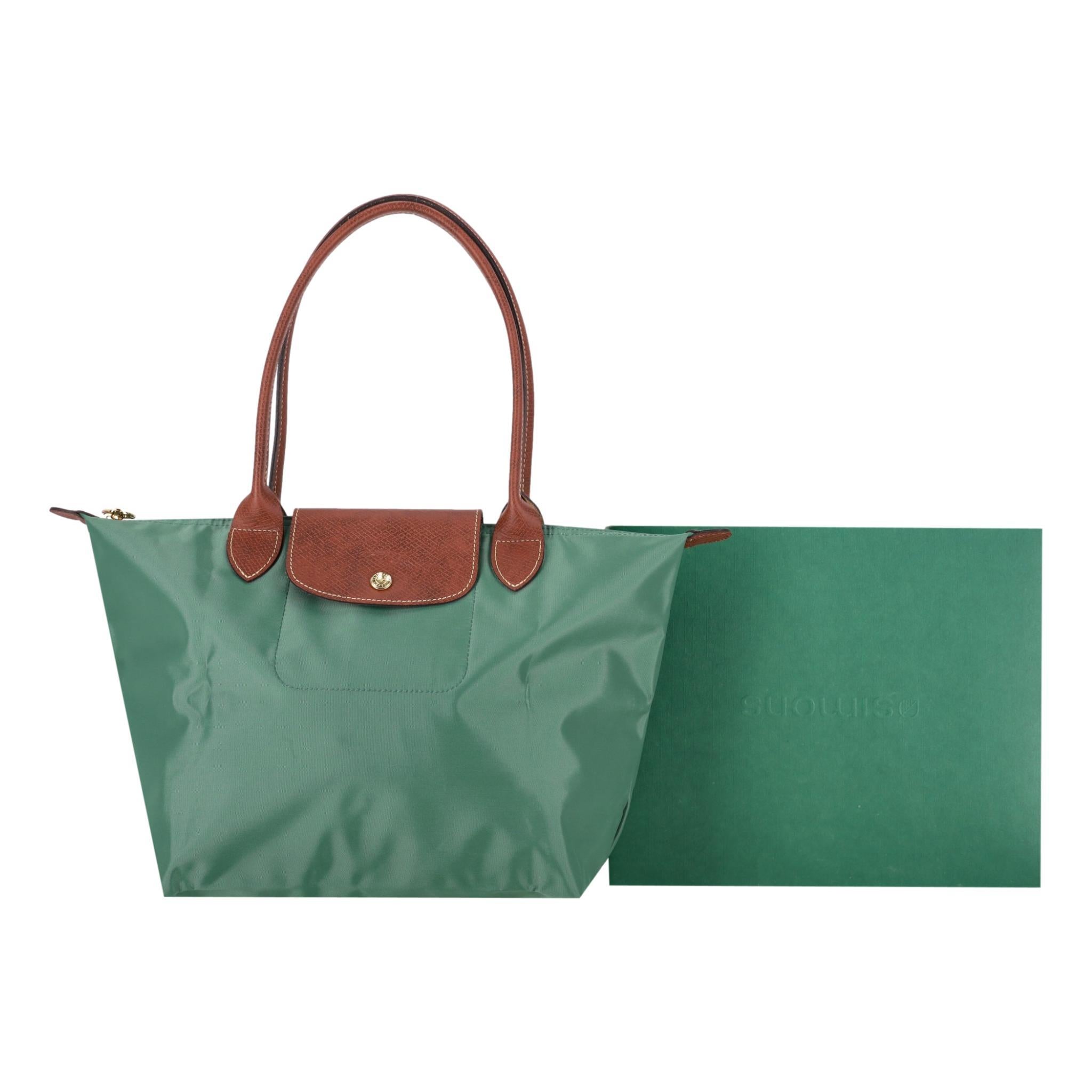 Longchamp Le Pliage Original Large Travel Bag

Green nylon travel bag with brown leather details.

Featuring dual tope handles and snap and zip top closure leading to spacious interior.

Detailed with logo embossment to the leather.

Rrp £120

Size