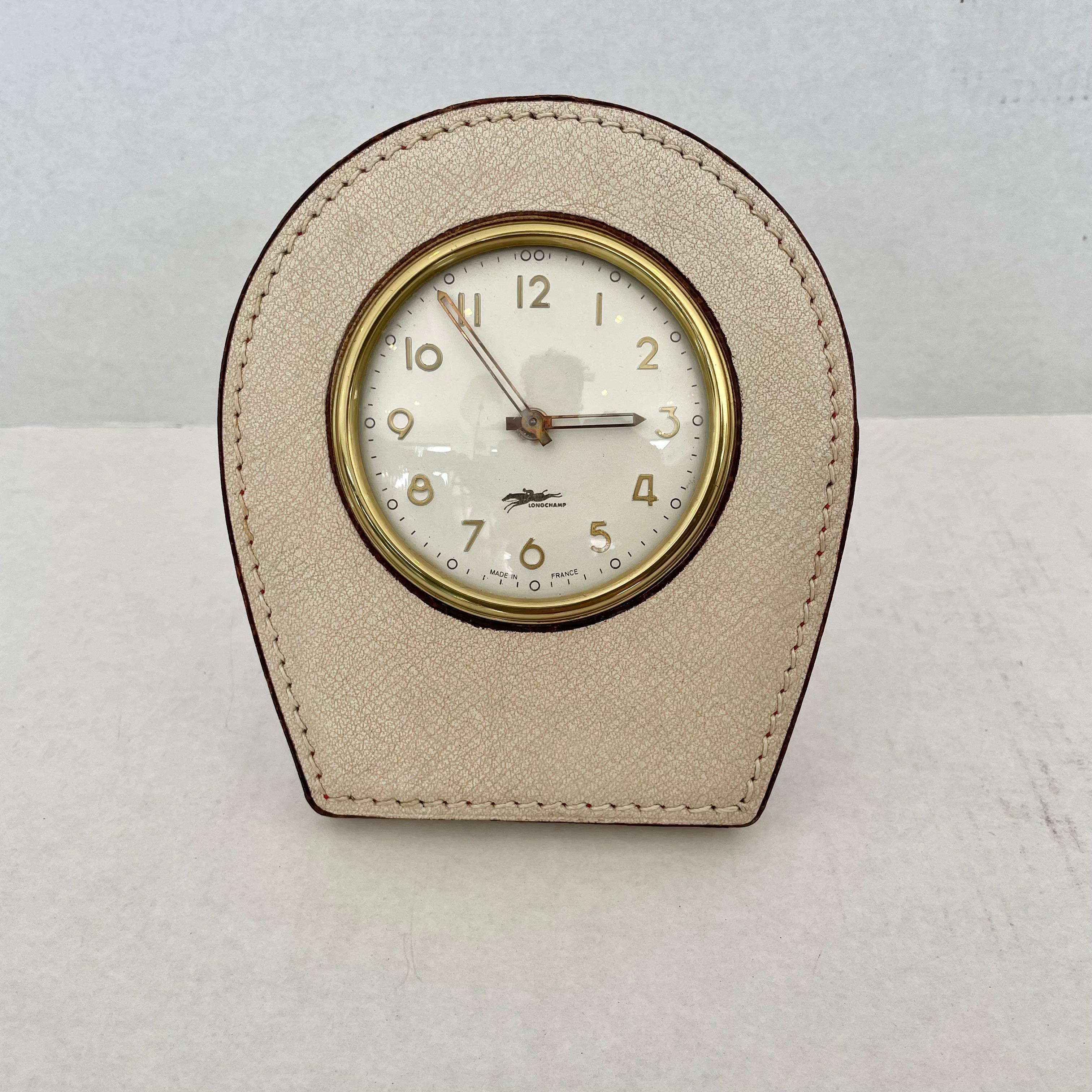 Handsome French leather desk clock by Longchamp. Keeps good time. Winds in the back and has an exposed knob to set time. Excellent patina to cream leather. Great vintage condition.
