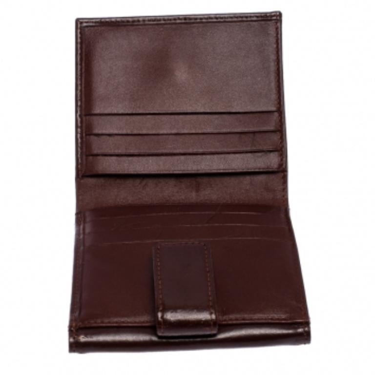 Rimani organizzato con stile con questo portafoglio di Longchamps. Dal design compatto, è realizzata in pelle in una ricca tonalità marrone. L'interno foderato in pelle e tessuto è dotato di più scomparti per le carte, una tasca per le monete e uno