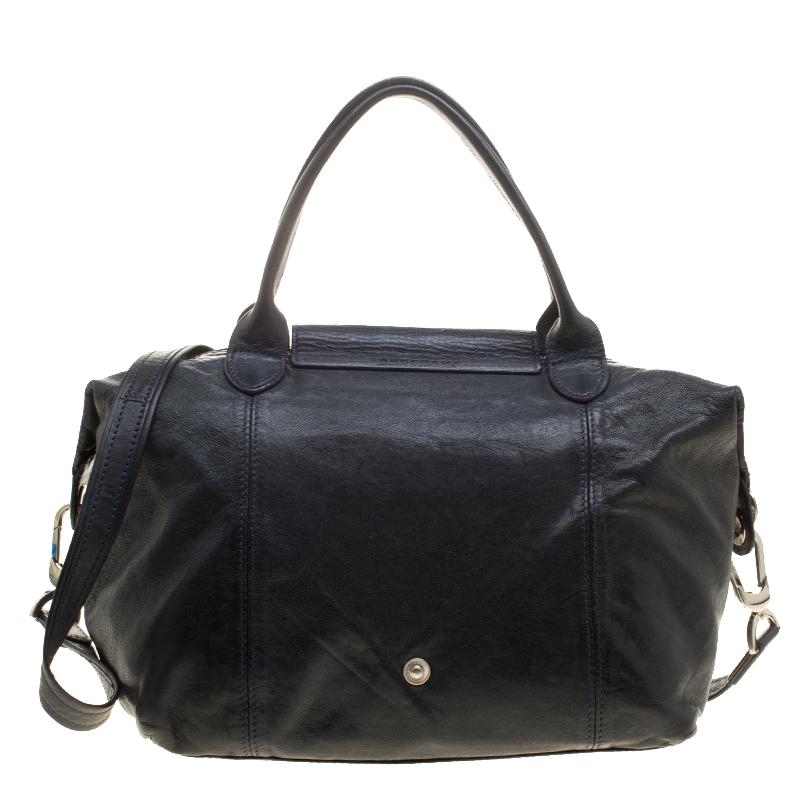 From the fashion house of Longchamp comes this tote that is absolutely flaunt-worthy. The bag is a piece from their famous Le Pliage collection. It has been crafted from leather in a head-turning navy blue hue and styled with two top handles and a