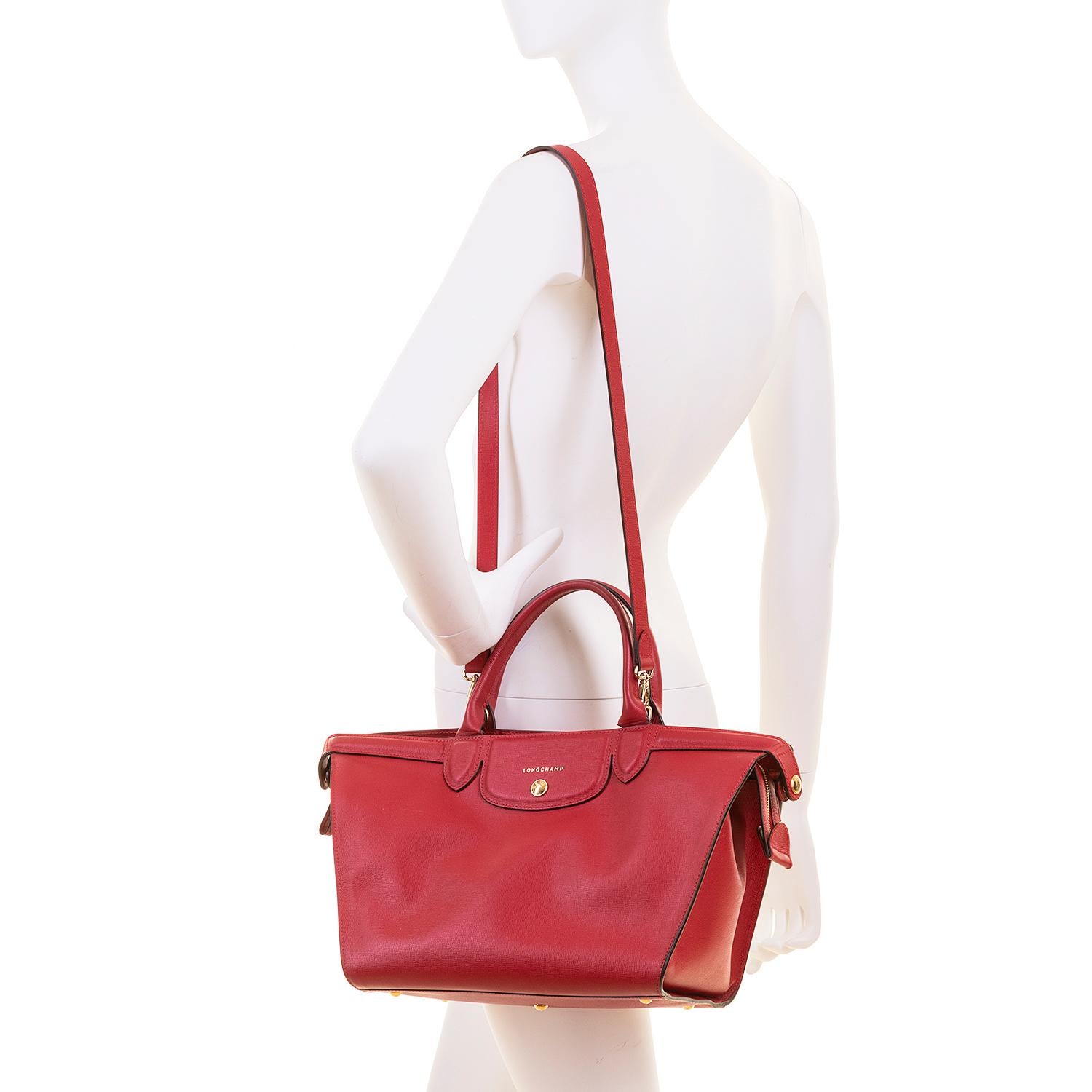 For travel or shopping this Longchamp bag is ideal. Finished in red leather with gold hardware, the bag is 'Tres-Chic' and with it's detachable strap, can be worn as a shoulder, cross-body or hand-bag. In excellent condition throughout, the bag