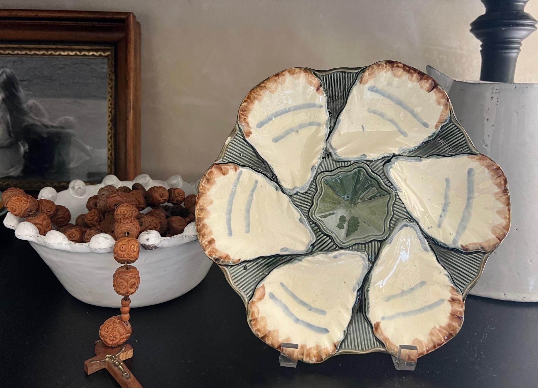 Antique oyster plate made in France around 1900 by Longchamp. The plate includes six elongated shells with a center well for lemon slices.  Stamped on the bottom.
