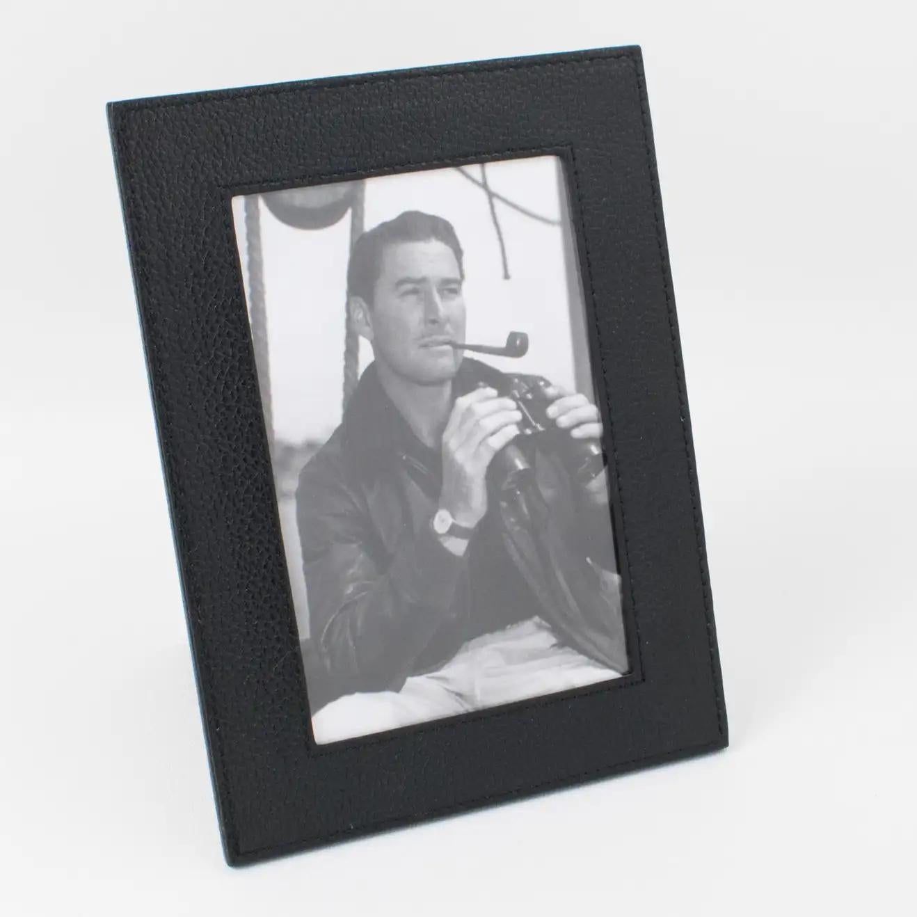 Longchamp, Paris, designed and crafted this elegant modern leather picture photo frame in the 1980s. The black calfskin leather has a pattern and hand-stitched finish. The easel and back are in the same black leather, and the frame has glass