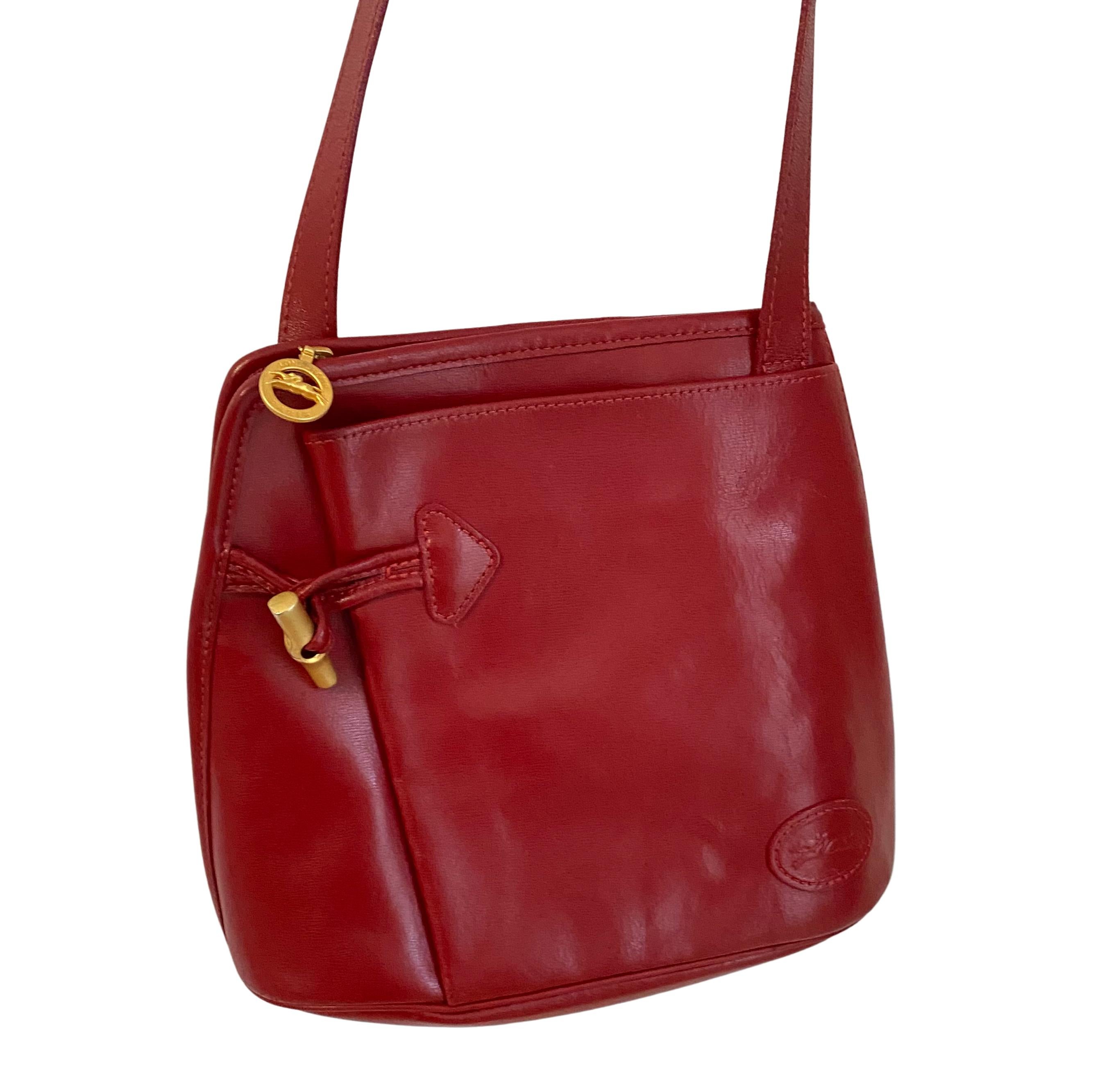 Lipstick red leather Longchamp Paris crossbody bag from France.
Foldover design. 
Zip closing. Gold Longchamp zipper pull and embossed logo on the front.
Approximately 9