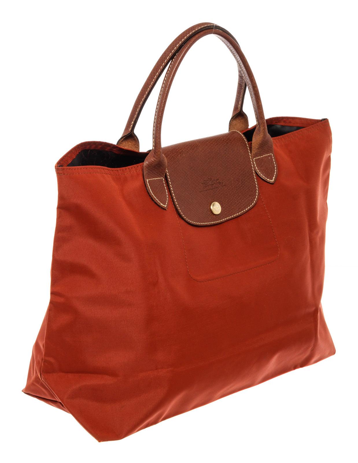 Longchamp Red Nylon Le Pliage Medium no zipper tote bag with gold-tone hardware, fabric interior lining, one slip pocket at interior wall and double brown leather top handles.
 


46568MSC

 17
