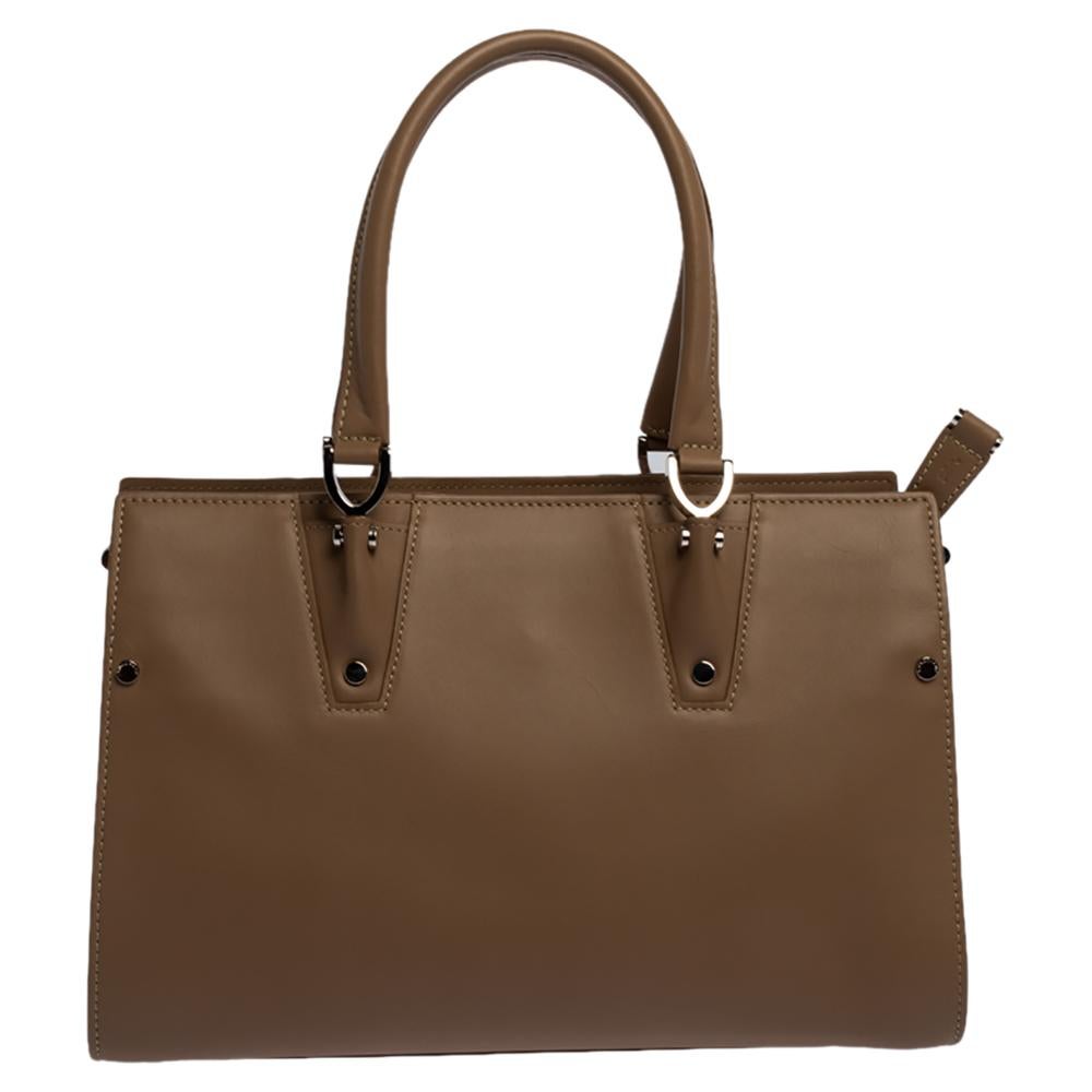 This stunning tote by Longchamp is crafted from leather and has been designed to deliver class and sophistication. It comes with dual handles, top-zip closure, a leather interior, a brand logo on the front, and silver-tone hardware. It makes for a