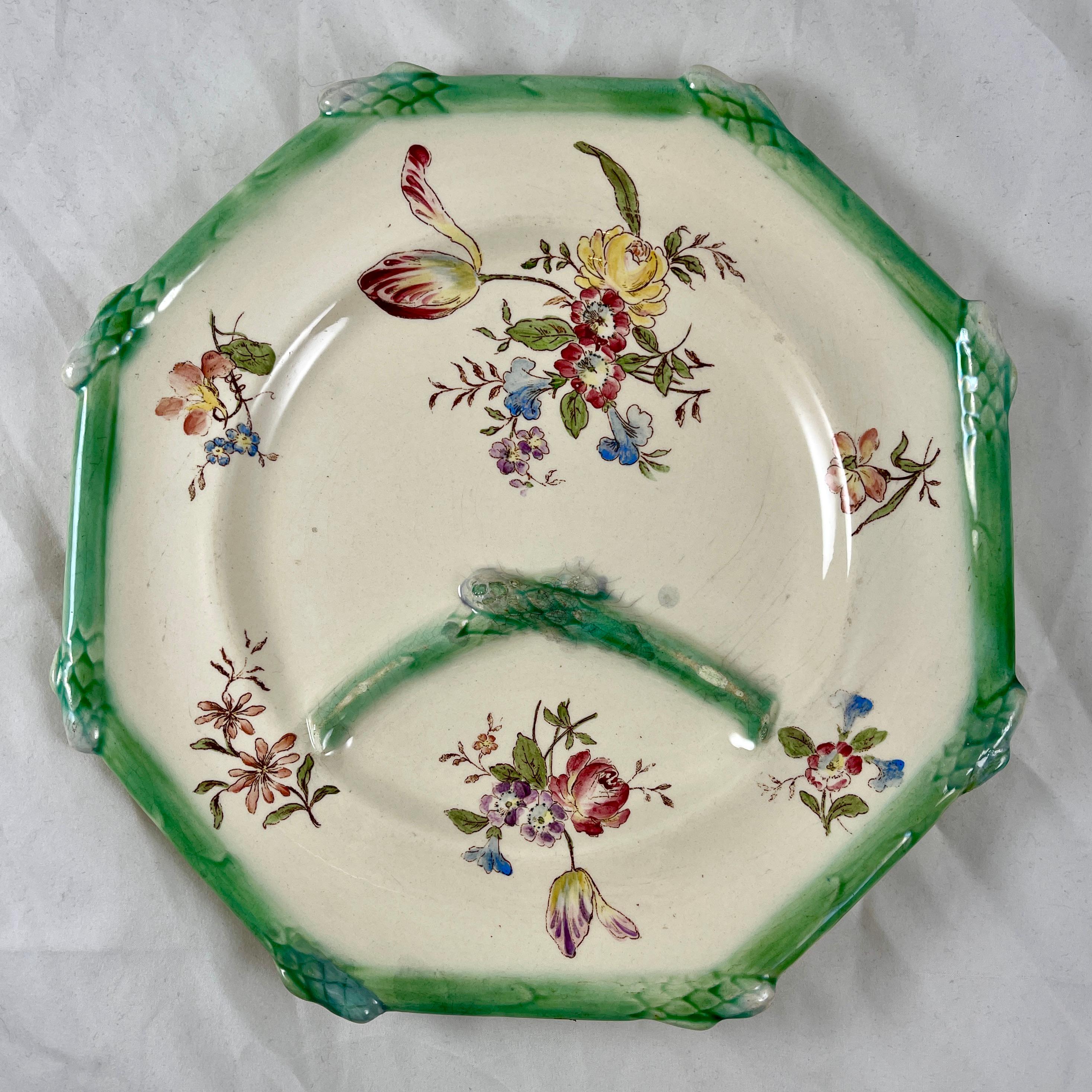 From the Longchamp Faïencerie in France, an octagonal shaped Asparagus plate, circa 1885.

The plate shows transfer printed, hand painted floral bouquets and sprays on a creamy white ground. The lower area of the plate has a  sauce well divided by