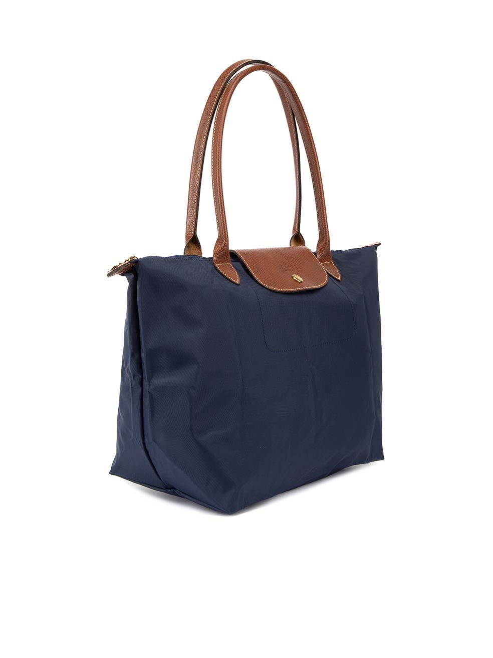 CONDITION is Never Worn. No visible wear to bag is evident on this used Longchamp designer resale item. Details Navy Nylon Large tote bag Collapsible with snap button closure Brown leather trims 2x Rolled top handle Top snap button and top zip