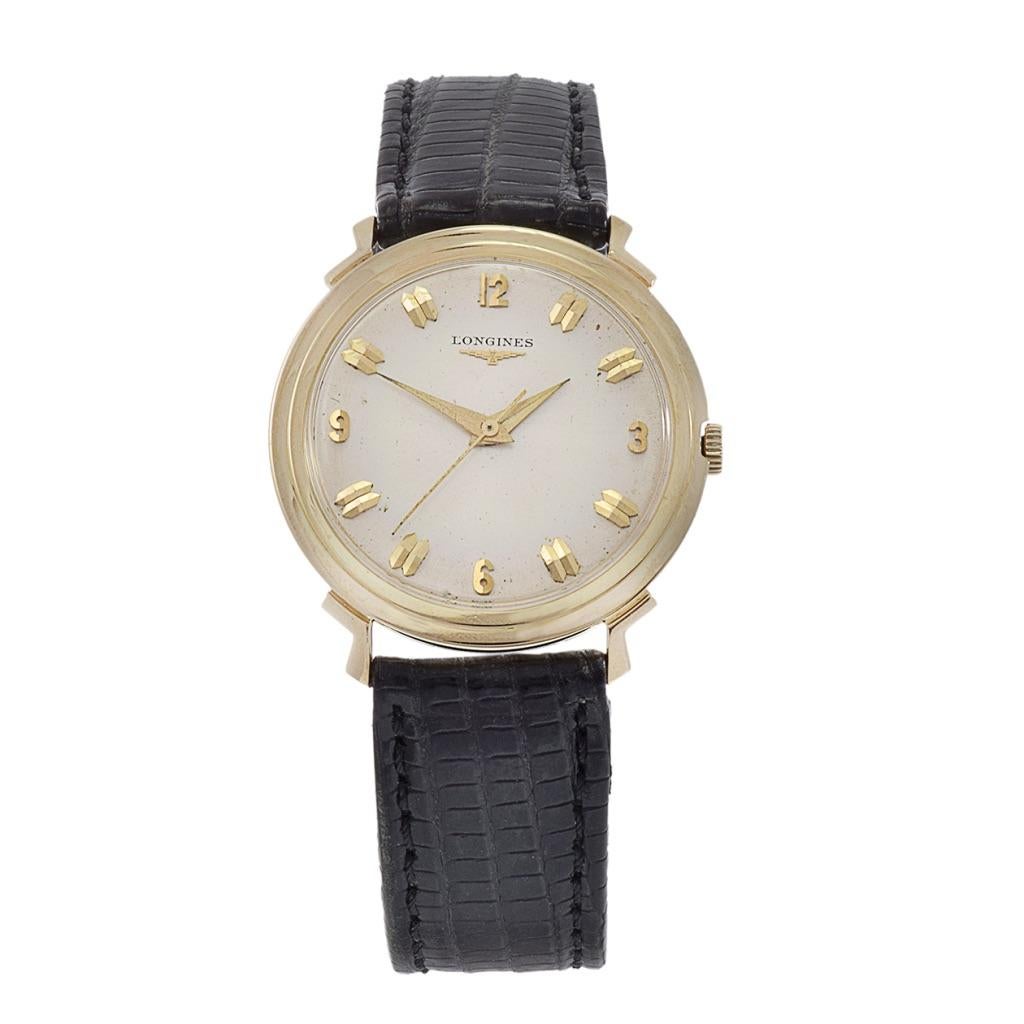 This vintage Longines watch from the 1960s is a true classic, featuring a 33mm 14kt yellow gold case. Its silver dial is adorned with gold markers, complemented by Dauphine hands, and distinguished by a large sweeping second hand. This watch is