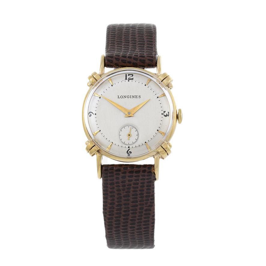 This is a beautiful 1950's Longines 14K gold Calatrava with ornate scroll lugs. The gold case measures 29mm in diameter.

The silver dial has Arabic indices and a seconds sub dial. The hands are an alpha shape.

The watch is powered by a 17 jewel