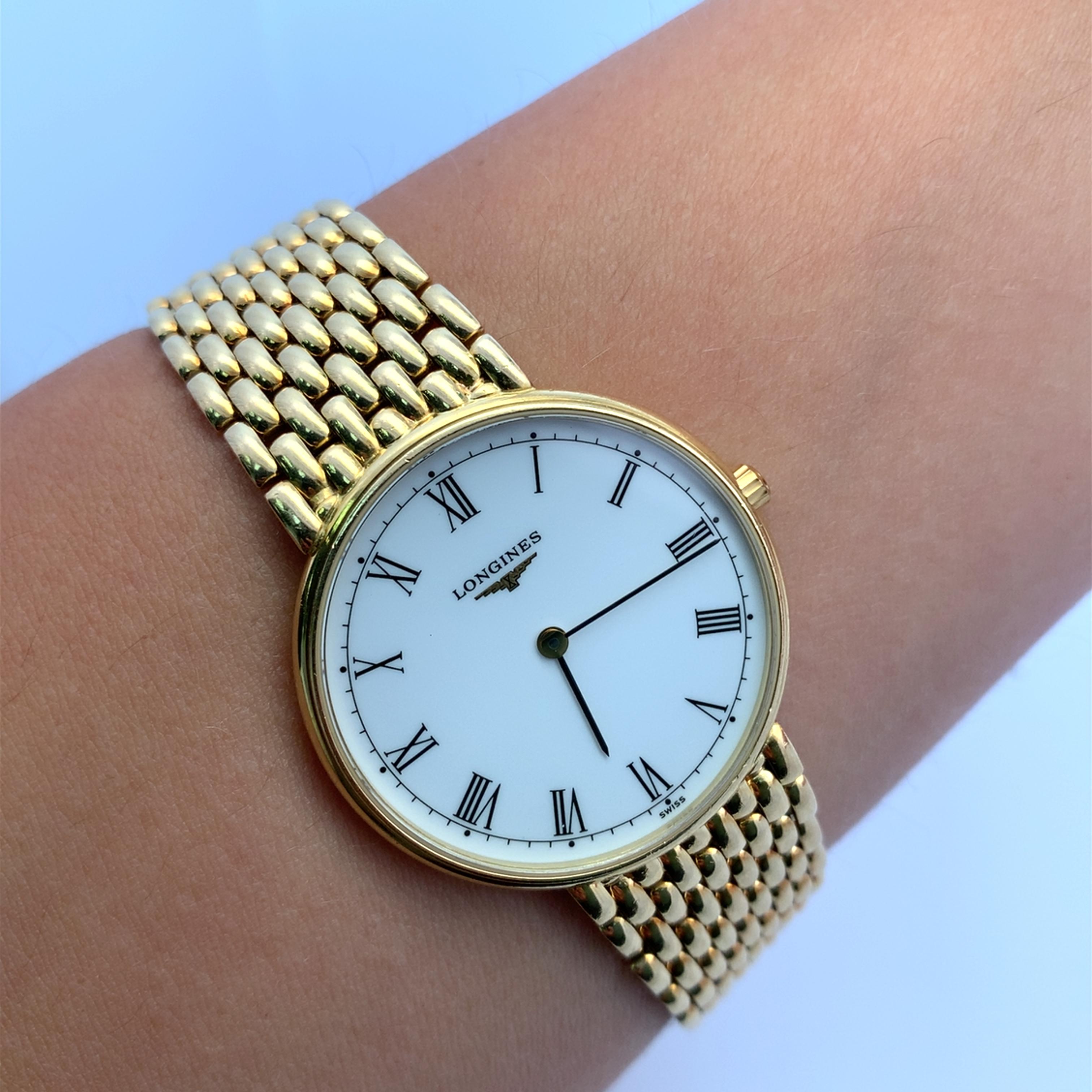 This stunning Longines 18k yellow gold watch features a classic design with Roman numerals, making it a timeless accessory for any occasion. The intricate woven band adds a touch of sophistication, ensuring it stands out on your wrist. Perfect for