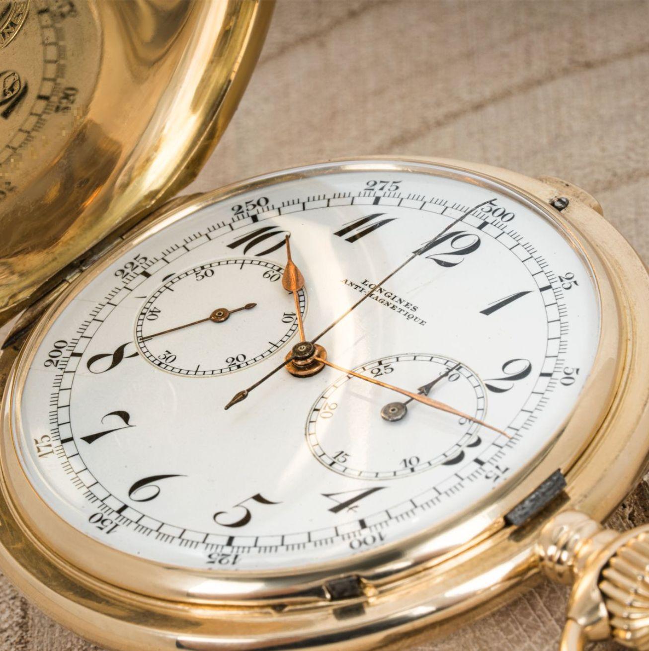 Longines. A Heavy 18ct Gold Keyless Lever Full Hunter Chronograph Pocket Watch C1900s.

Dial: The perfect white enamel dial fully signed Longines Anti-Magnetique with Arabic numerals, outer tachymeter track, subsidiary seconds dial at nine o'clock