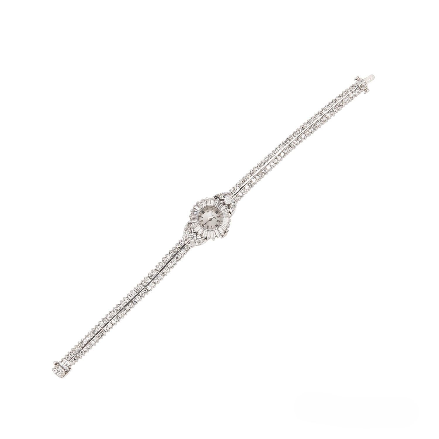 This vintage Longines watch features bezel set with approximately 4.50 carats of baguette-cut diamonds, full and marquise-cut diamonds, joined to a bracelet set with single-cut diamonds, all delicately set in platinum with a safety clasp closure. 