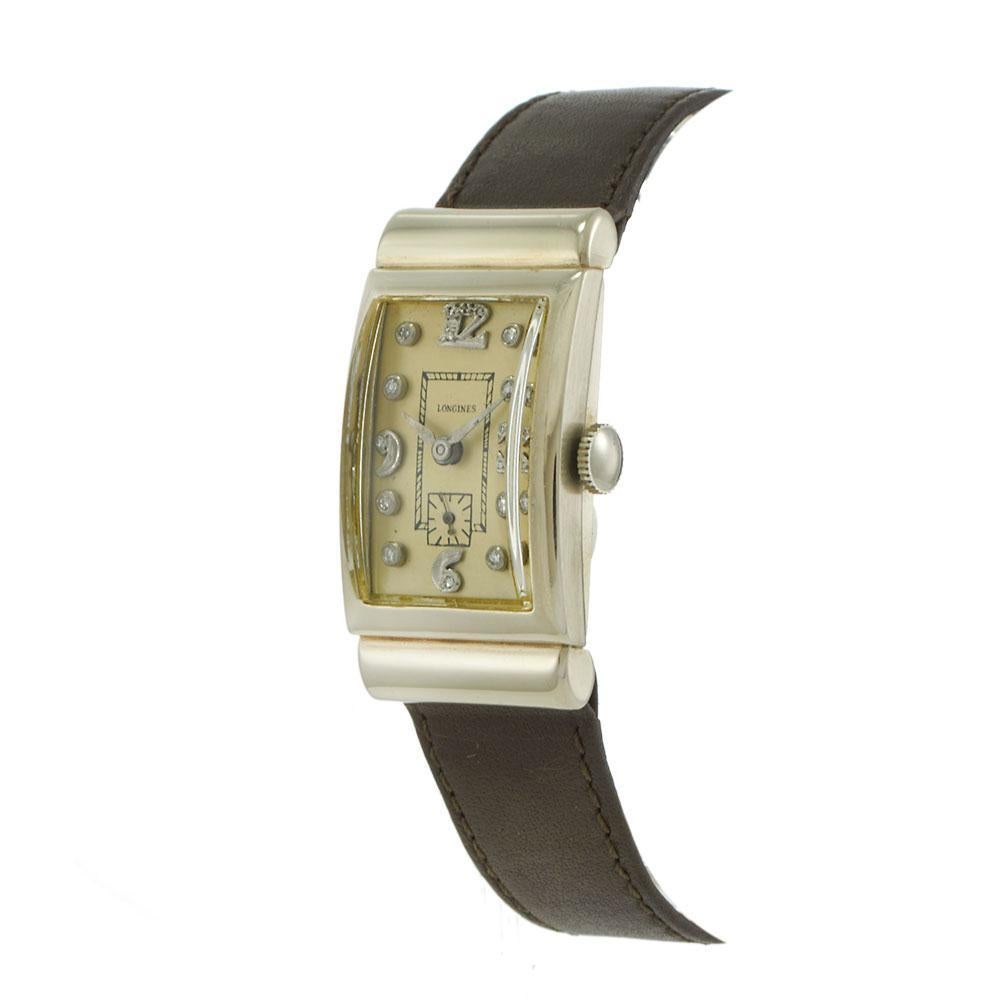 Vintage 1942 Longines watch featuring a 21.5 x 40.5mm rectangular 14KT white gold case. The silver dial has developed an even patina over time and features diamond hour markers with a sub-dial for the seconds at 6 o'clock. Powered by a manual wind
