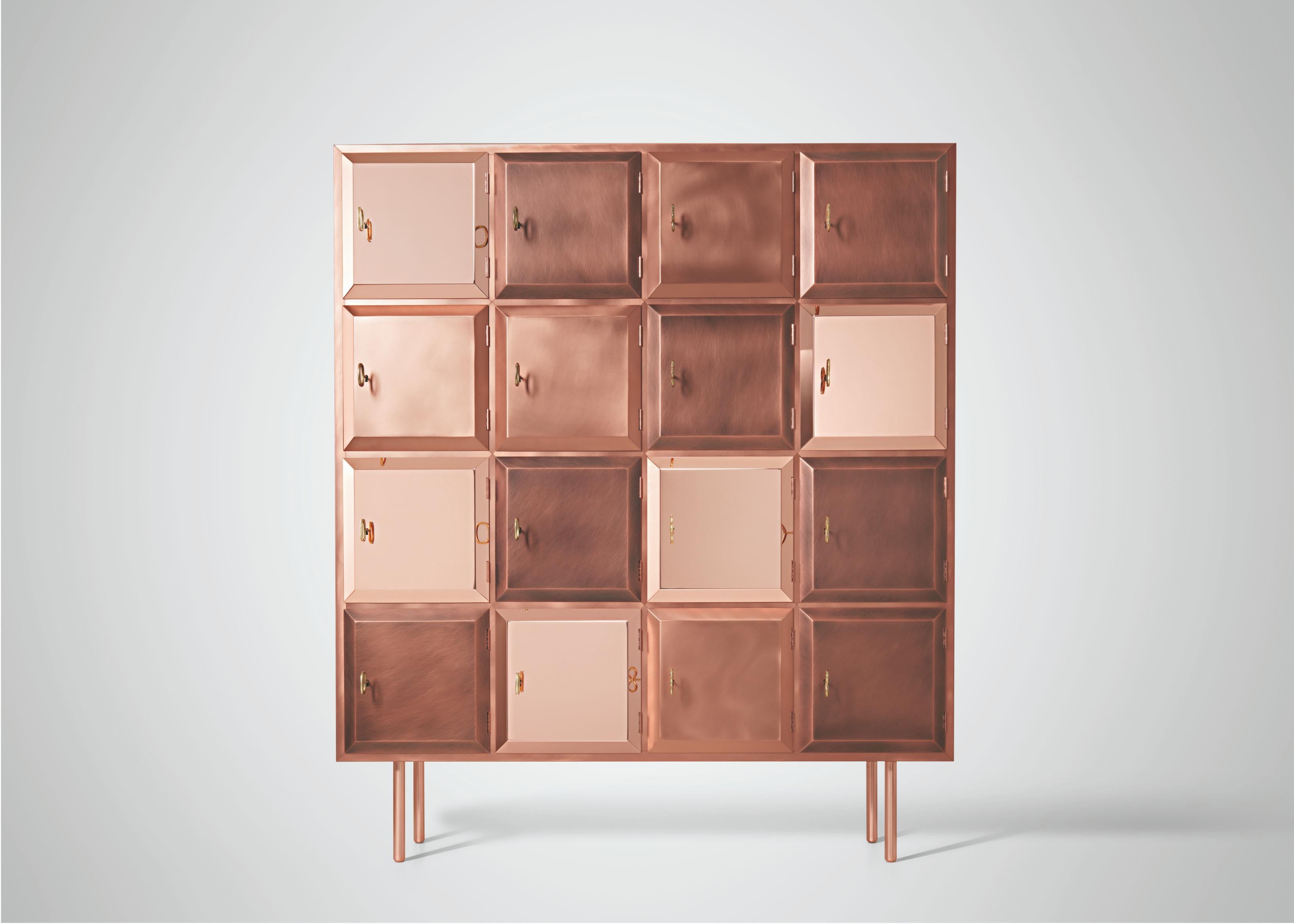 Armadio del desiderio di De Castelli
Dimensioni: L. 150 x P. 47 x H. 177 cm
Materiali: Rame misto, Wood
È disponibile anche la versione in ottone. Contattaci per qualsiasi richiesta.

Composto da piccoli scomparti quadrati, questo armadietto dei