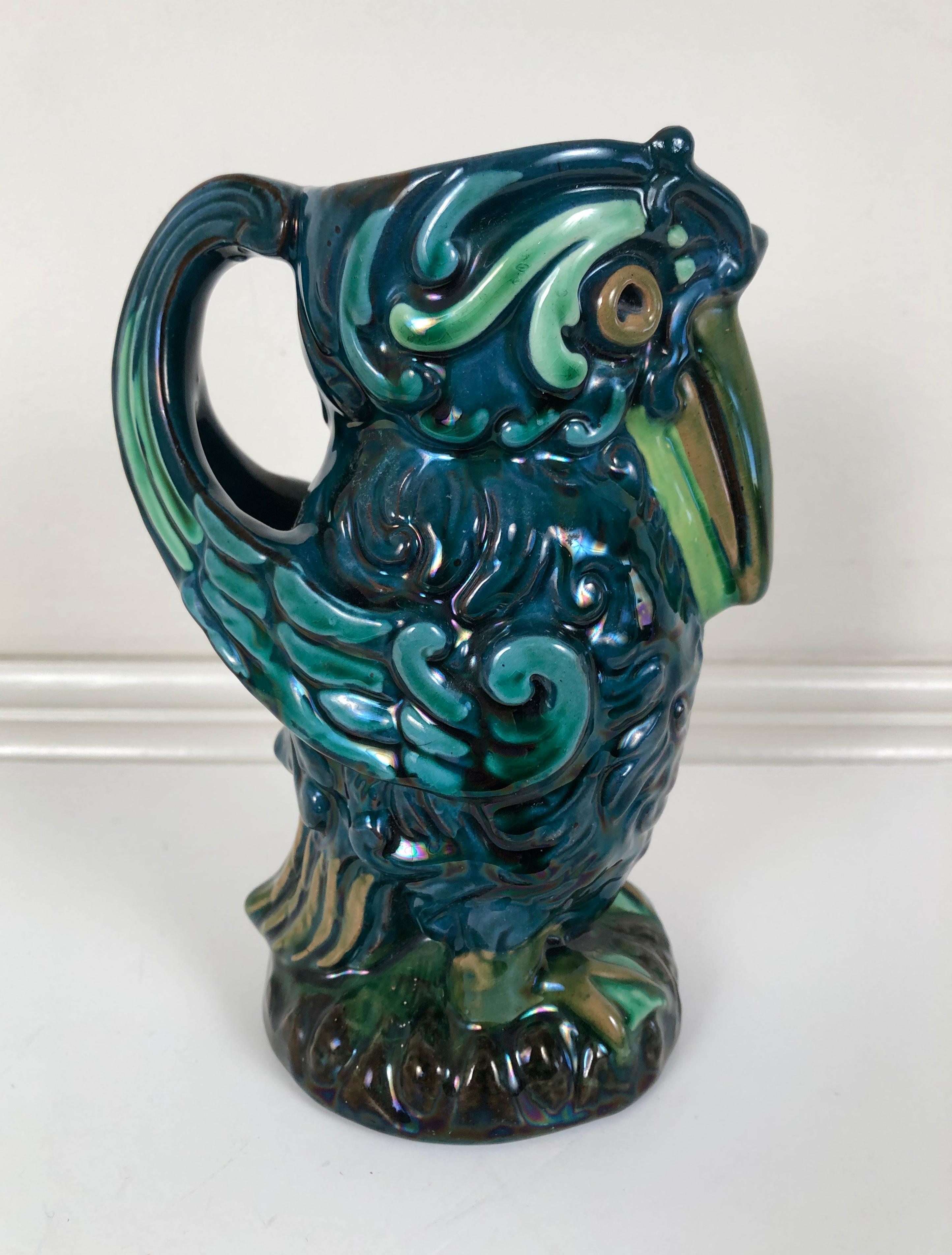 An Arts and Crafts period Longpark English pottery pitcher, whimsically modeled as a bird in beautiful green, blue and brown glazes, with large eyes and beak and an integrated wing handle.
 
