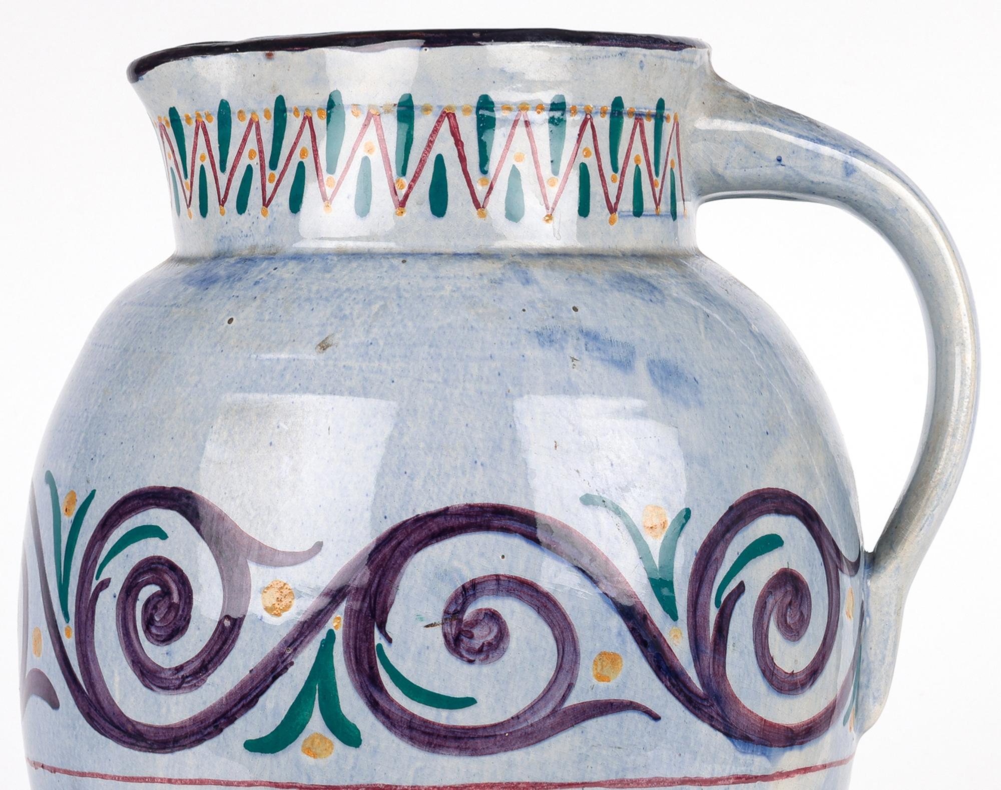 A stunning and large Longpark Torquay hand painted art pottery jug, believed to be an exhibition piece dating from the 1920’s. The red terracotta clay jug is heavily made and of large bulbous form with scroll and linear patterning painted in colored