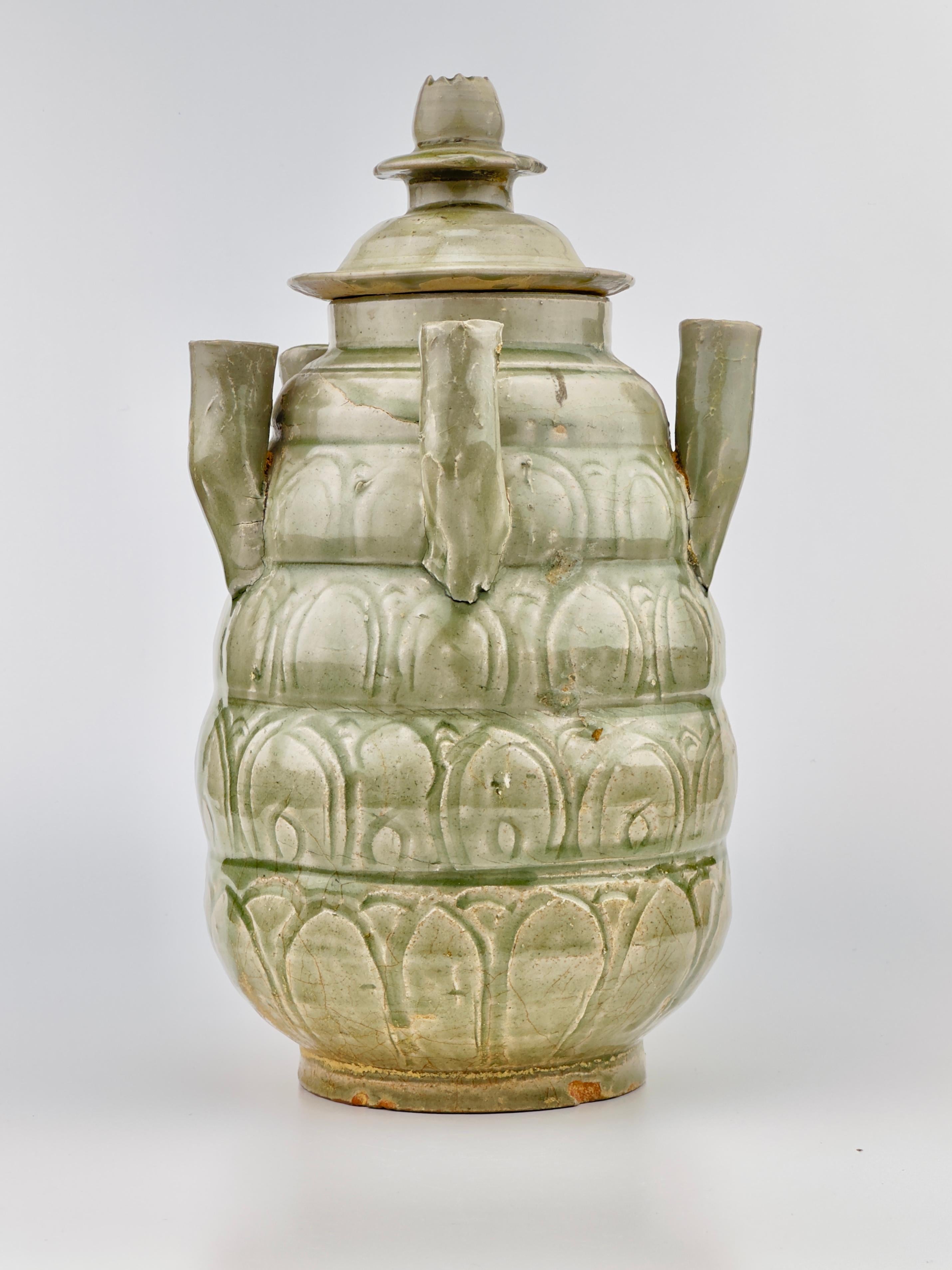 Thickly potted with an ovoid body of five horizontal lobes tapering toward the top, carries both aesthetic and practical values. The jar is intricately carved with rows of upright lotus petals beneath a band of vertical lines, a design that is both