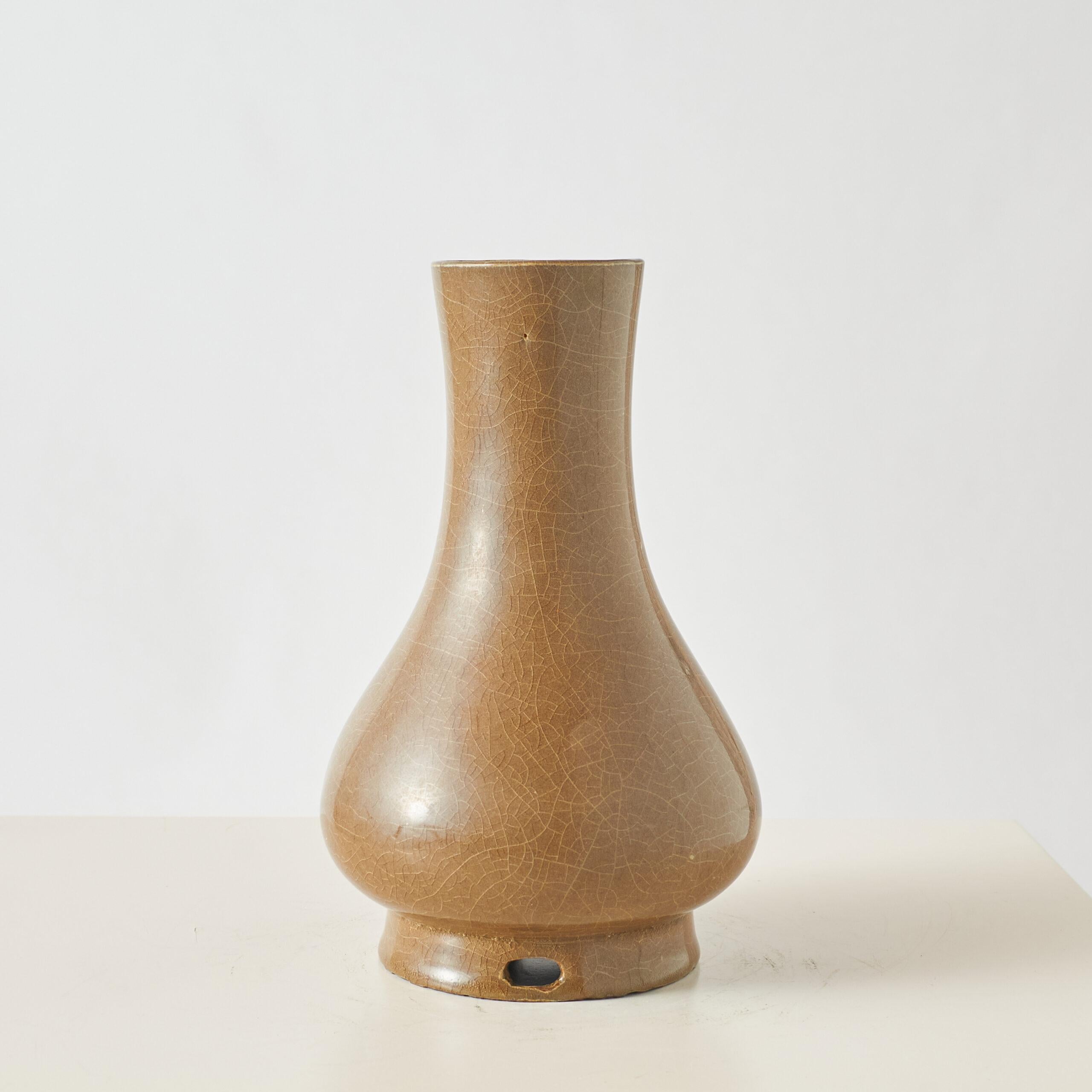 Longquan-Celadon-Vase mit brauner Teerosenglasur

Vase aus Steinzeug mit birnenförmigem Korpus, hohem Hals und ausgestelltem Fuß, überzogen mit einer dicken, schokoladenbraunen Teerosenglasur. Die Oberfläche weist durchgehend feine Risse auf,