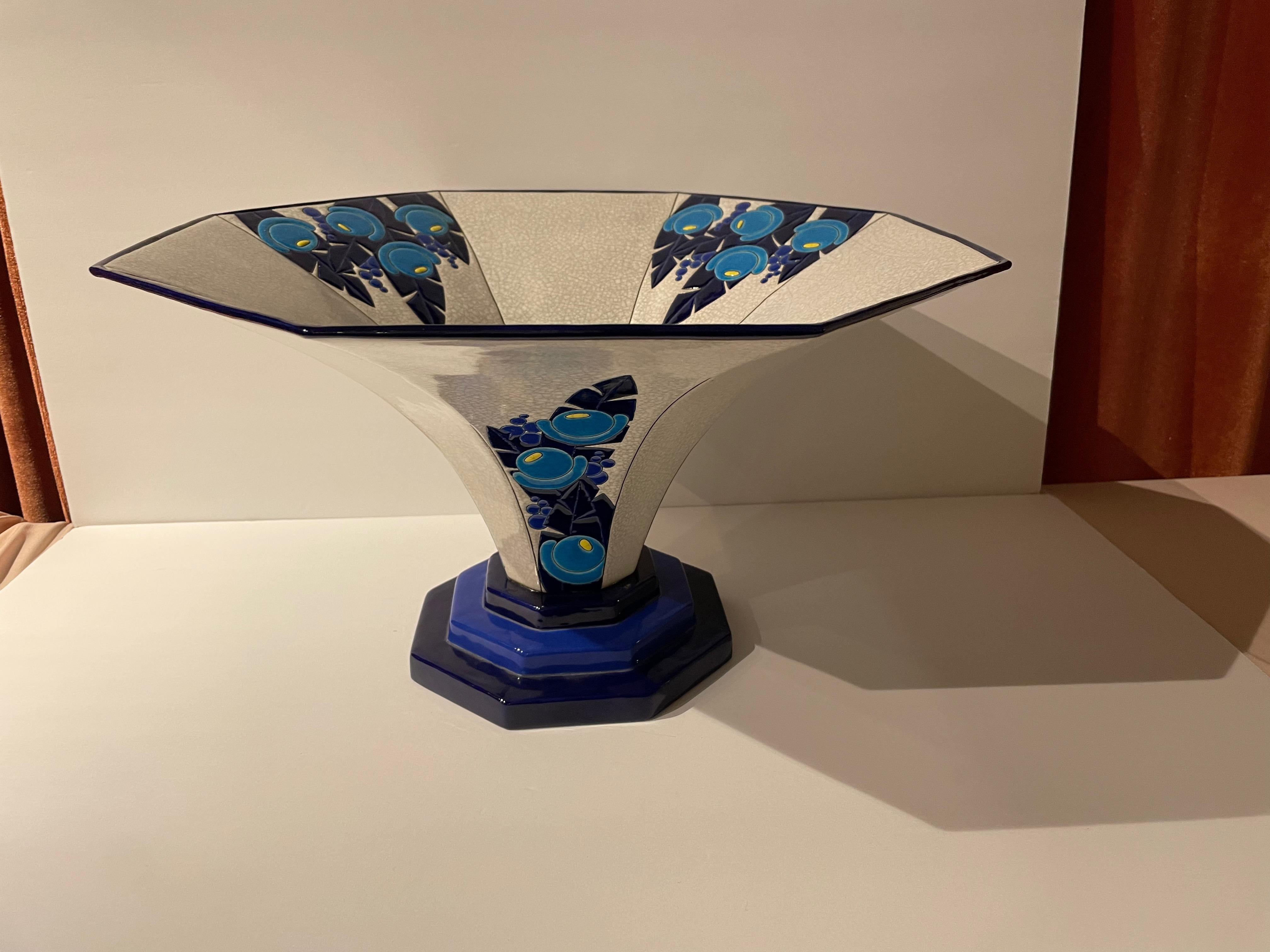 An Art Deco display or serving dish from Longwy. This piece is unusual for its large size and modernist embellishment. Using the classic colors of Longwy (the interplay of dark cobalt and light blues) but in a fresh approach with stylized tropical