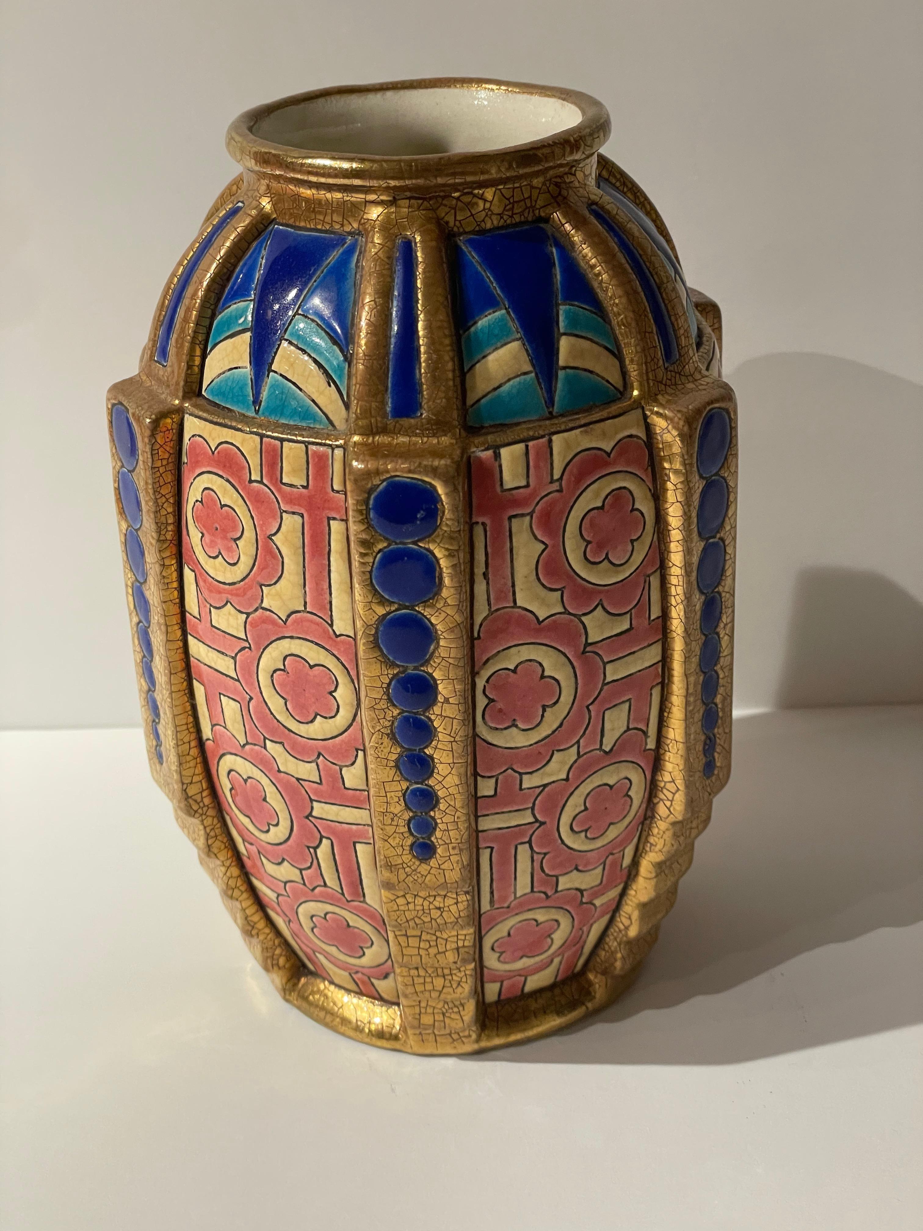 An Art Deco Longwy French vase with multidimensional details. The rich colors and unusual shape of this piece make it highly collectible. There is a wonderful use of gilding on the ribbed detail. This piece is in excellent condition and has so much