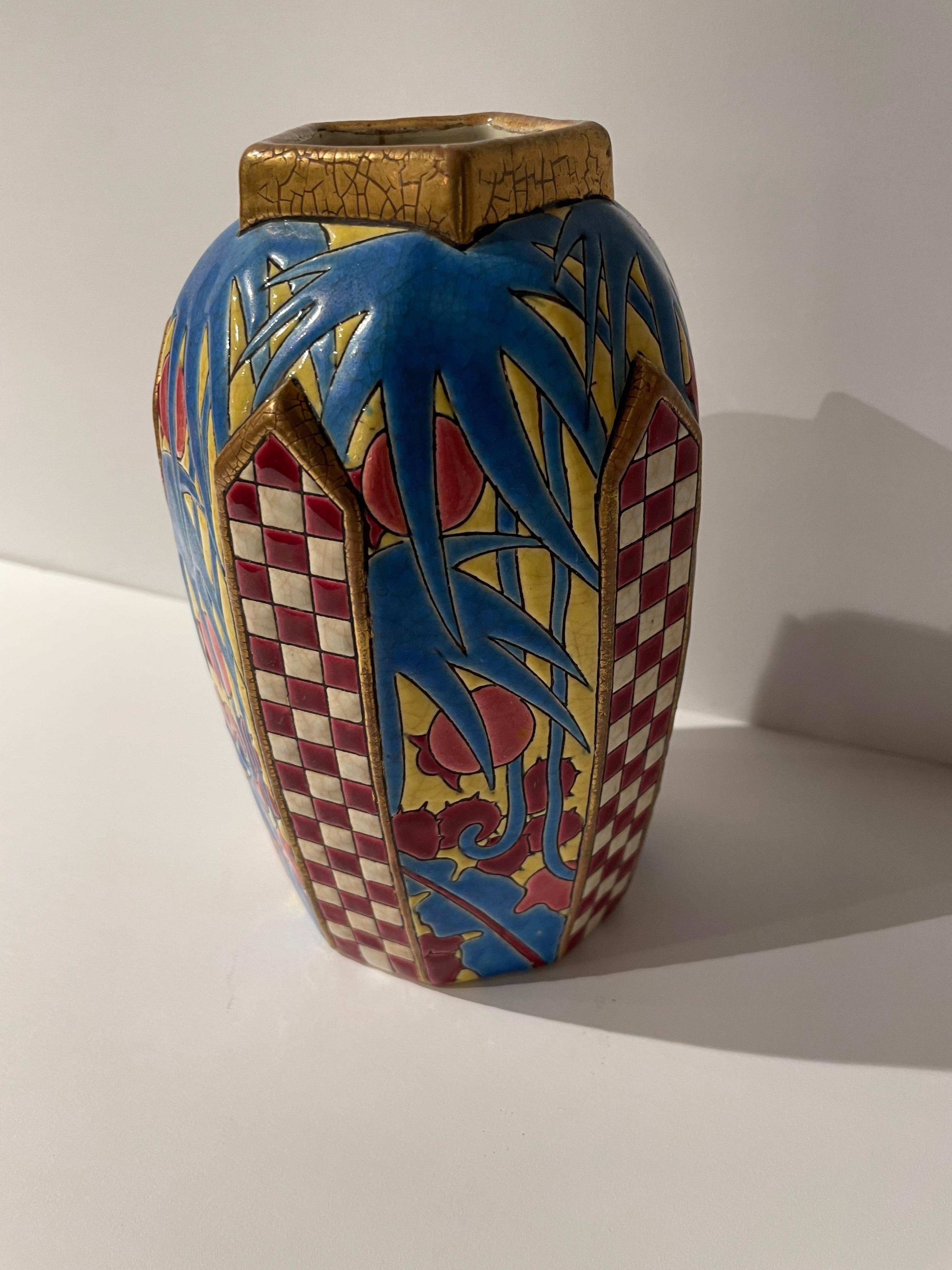 An Art Deco Longwy French vase with multidimensional details. The rich colors and unusual shape of this piece make it highly collectible. There is a wonderful use of gilding on the ribbed detail and the stepped base. This piece is in excellent