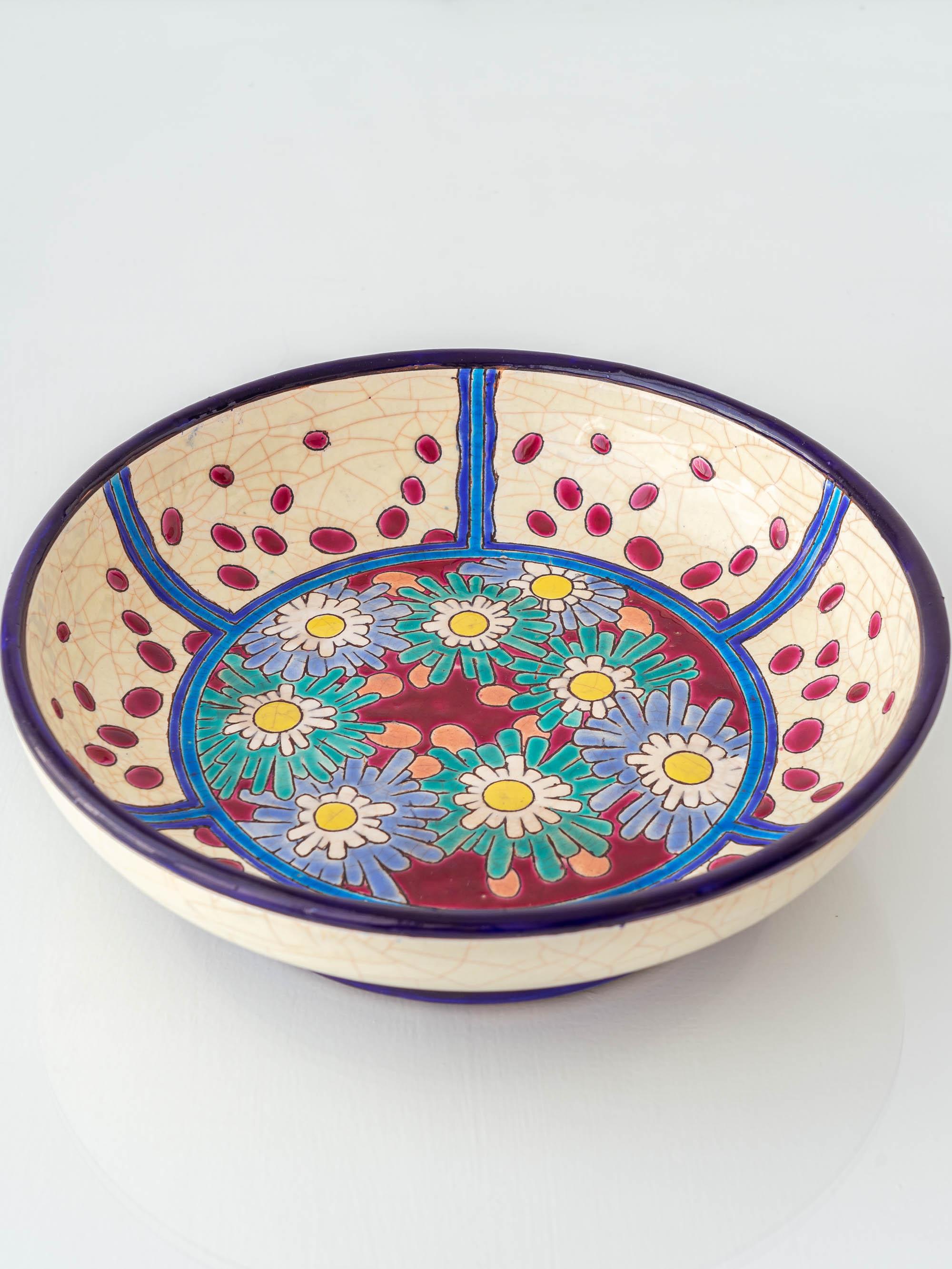 Diese Art-Déco-Schale von Longwy, die im Juli 1930 in Frankreich handgefertigt wurde, zeigt die berühmte Cloisonné-Emaillierung der Manufaktur in ihrer Blütezeit. Die Dekoration besteht aus stilisierten Gänseblümchen in Blau, Grün und Weiß auf rotem