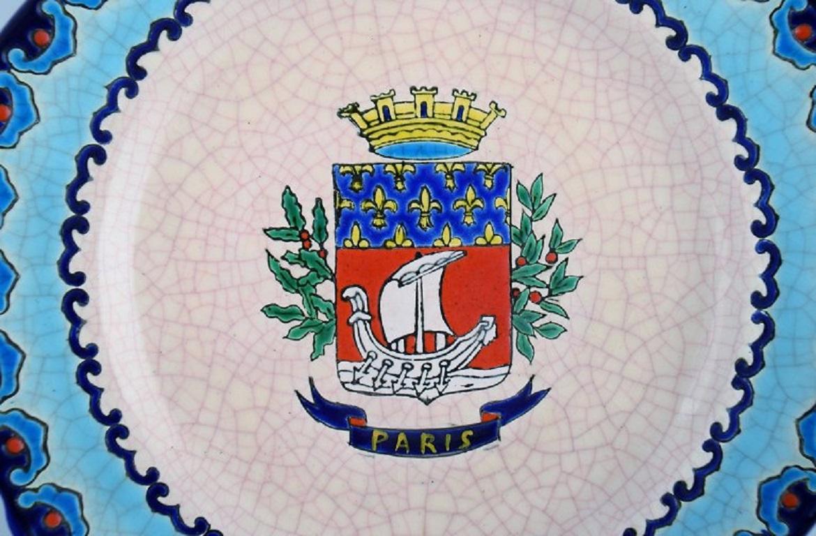 Longwy, France. Art Deco plate in glazed stoneware with the hand-painted Parisian coat of arms and foliage. 1920s / 30s.
Diameter: 23.5 cm.
In excellent condition.
Stamped.

Emaux de Longwy was founded in 1798.
The French town of Longwy, in