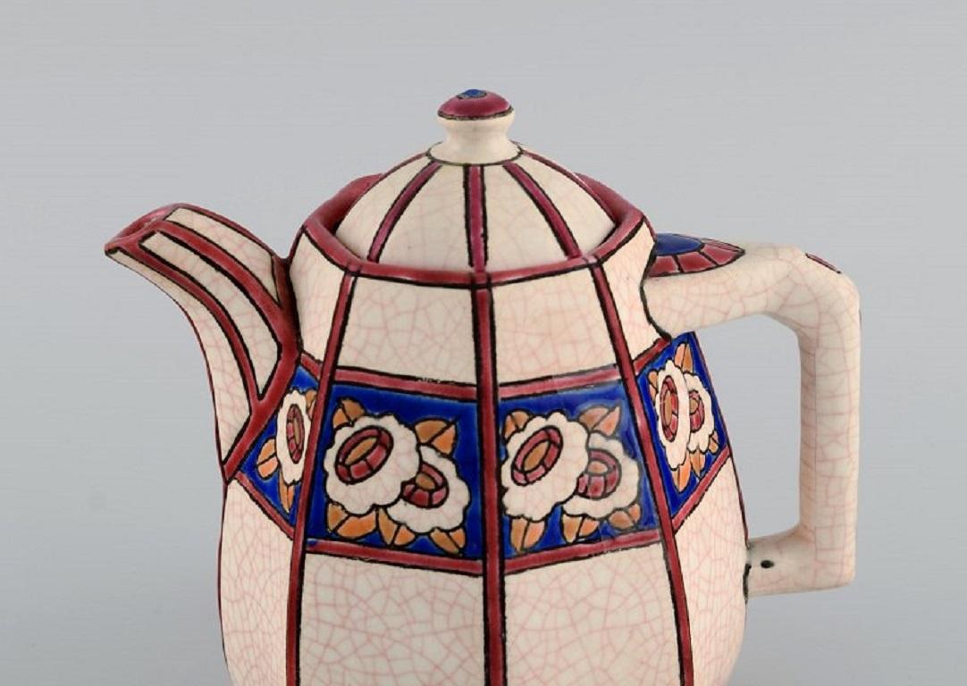 Longwy, France. Art Deco teapot in glazed stoneware with hand-painted flower decoration. 
1920s / 30s.
Measures: 15 x 14 cm.
In excellent condition.
Stamped.