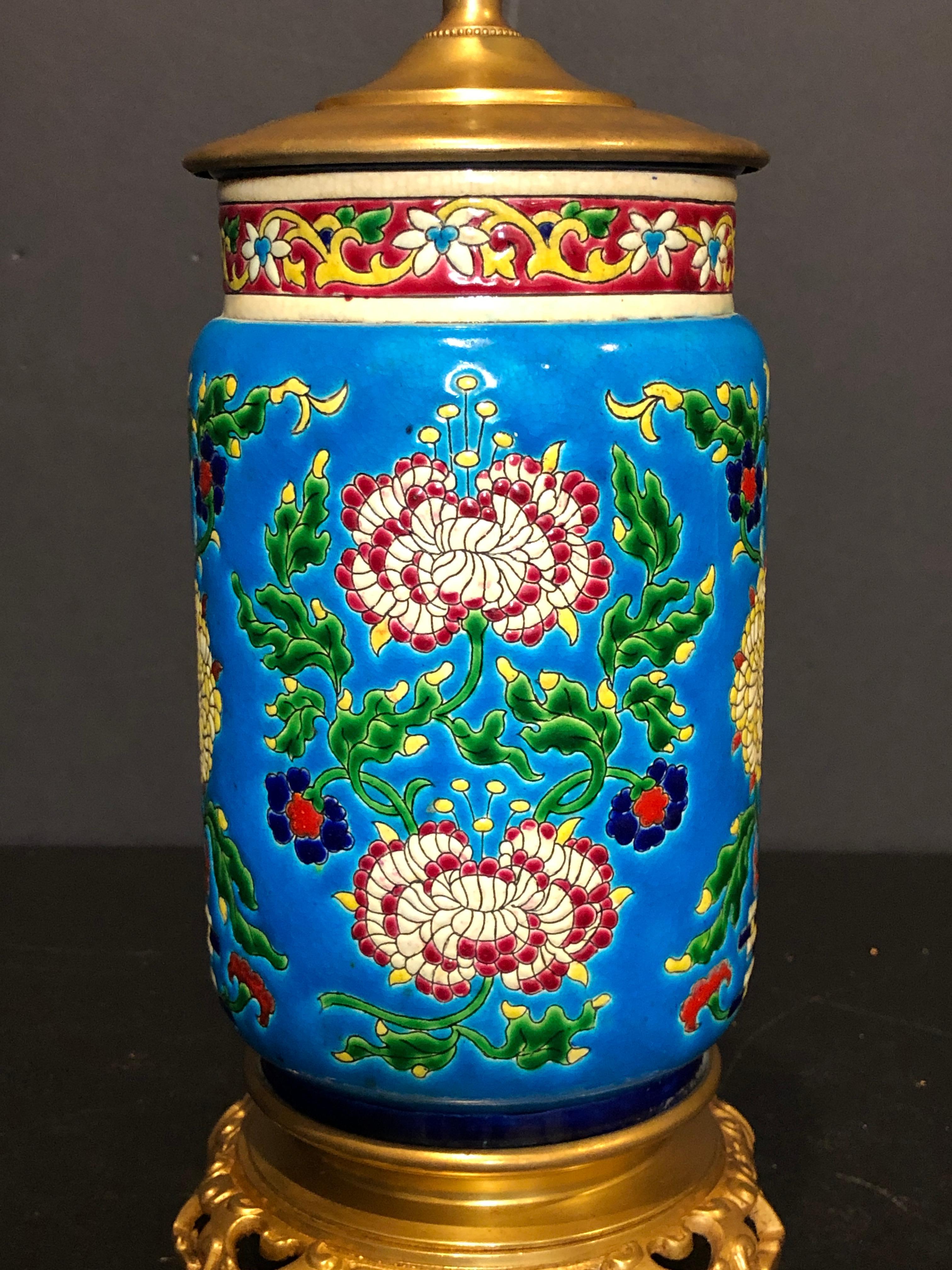 Longwy urn mounted as lamp. Colorful floral designs with chrysanthemum and geometric areas mounted on a gild bronze base with an Asian influence.
Measures: 11