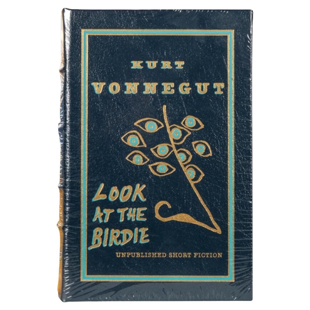 Vonnegut, Kurt. Look at the Birdie. Norwalk: The Easton Press, 2009. Limited Edition, of 1000 copies. Signed by Vonnegut. 8vo. Original pictorial blue leather stamped in black and gilt. Presented with its original and matching pictorial slipcase.