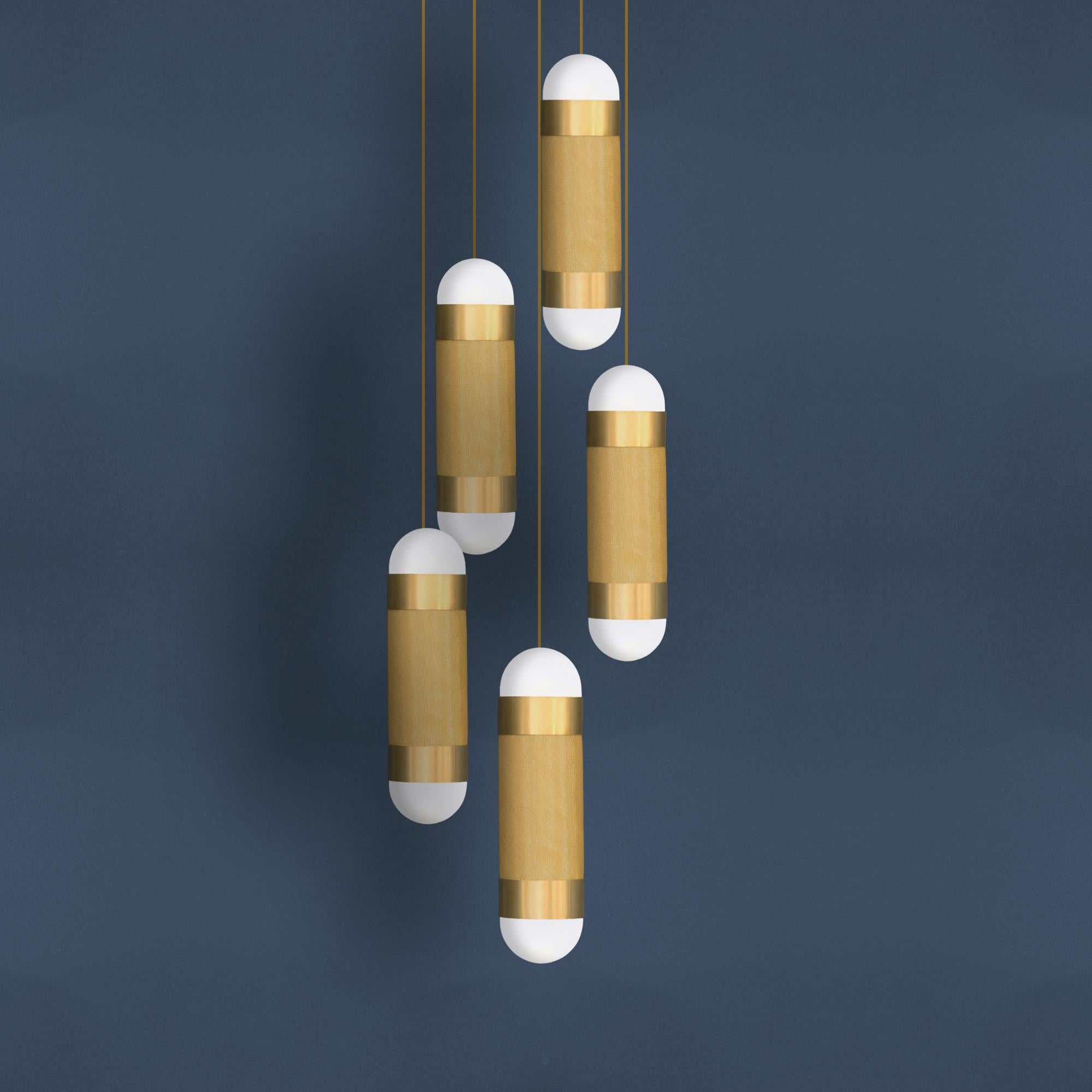 The LOOM 5 cascade pendant light is defined by its signature woven brass cylinder topped with hand-brushed brass sleeves and completed with soft-white borosilicate glass domes. When illuminated the LOOM emanates a soft, warm glow through the brass