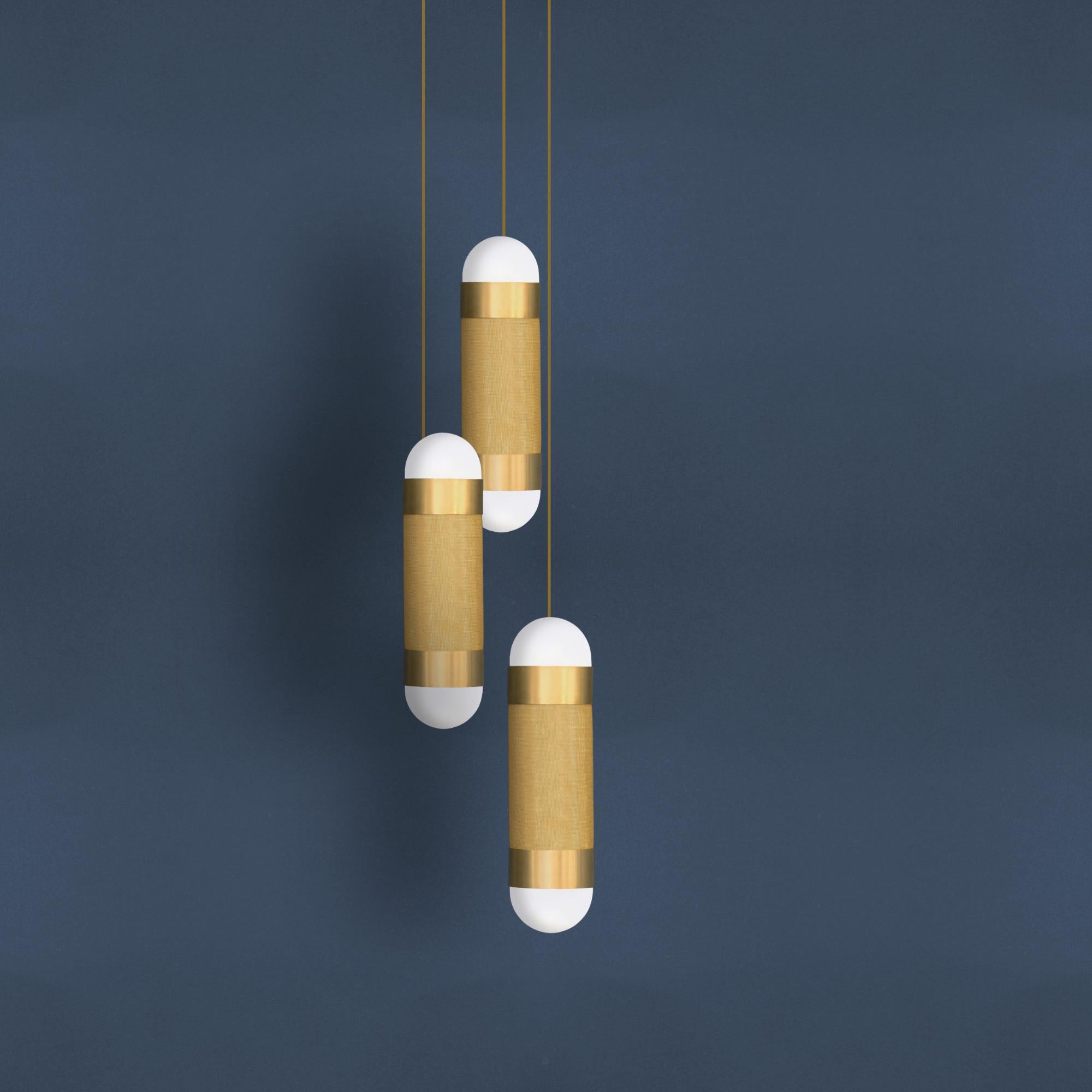The LOOM cascade pendant light is defined by its signature woven brass cylinder topped with hand-brushed brass sleeves and completed with soft-white borosilicate glass domes. When illuminated the LOOM emanates a soft, warm glow through the brass