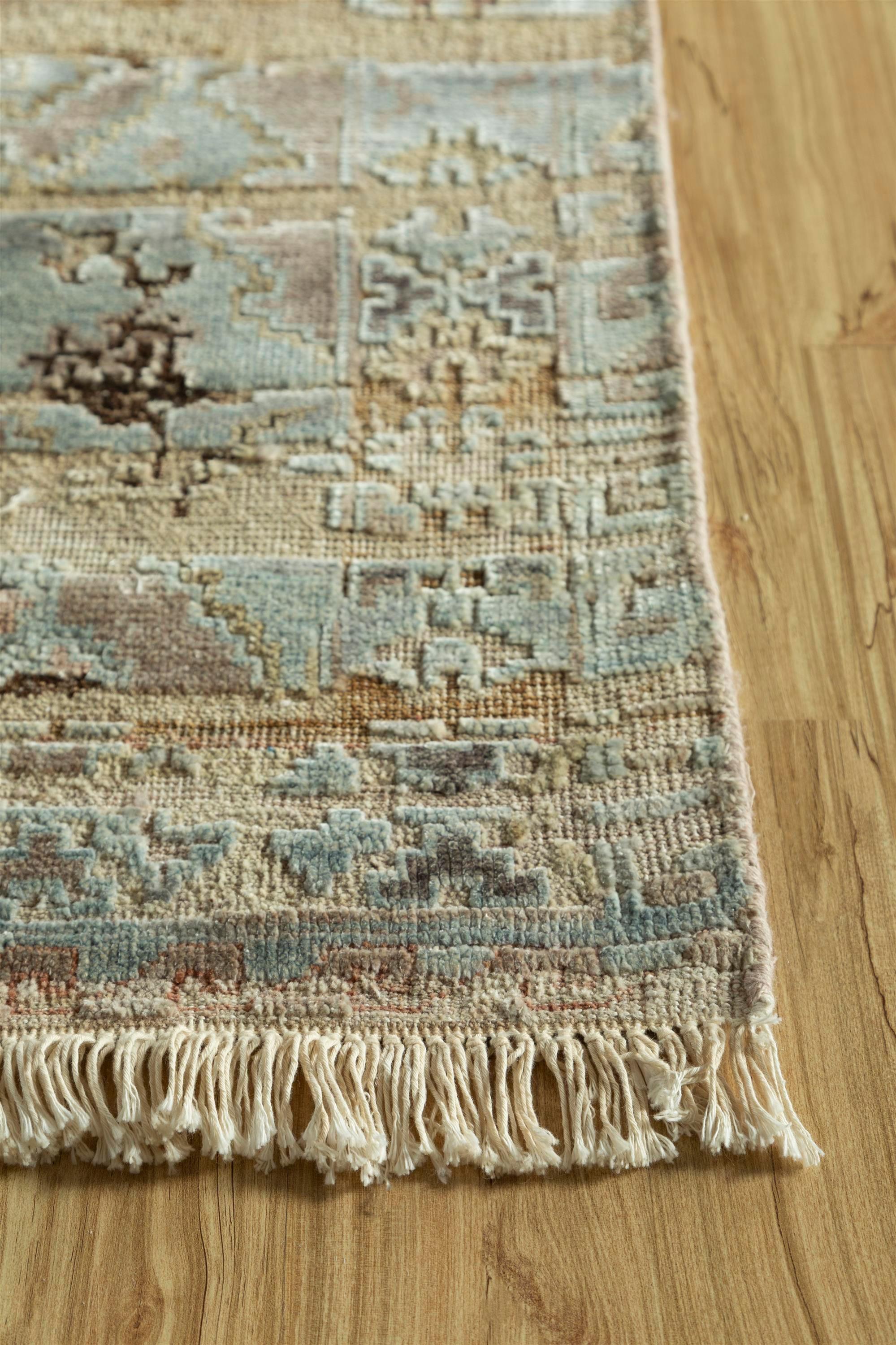 Embark on a voyage through timeless elegance with our hand-knotted rug, a veritable masterpiece woven from the luxurious embrace of wool and silk. Picture a soft beige canvas, serene and inviting, entwined seamlessly with a border dipped in a