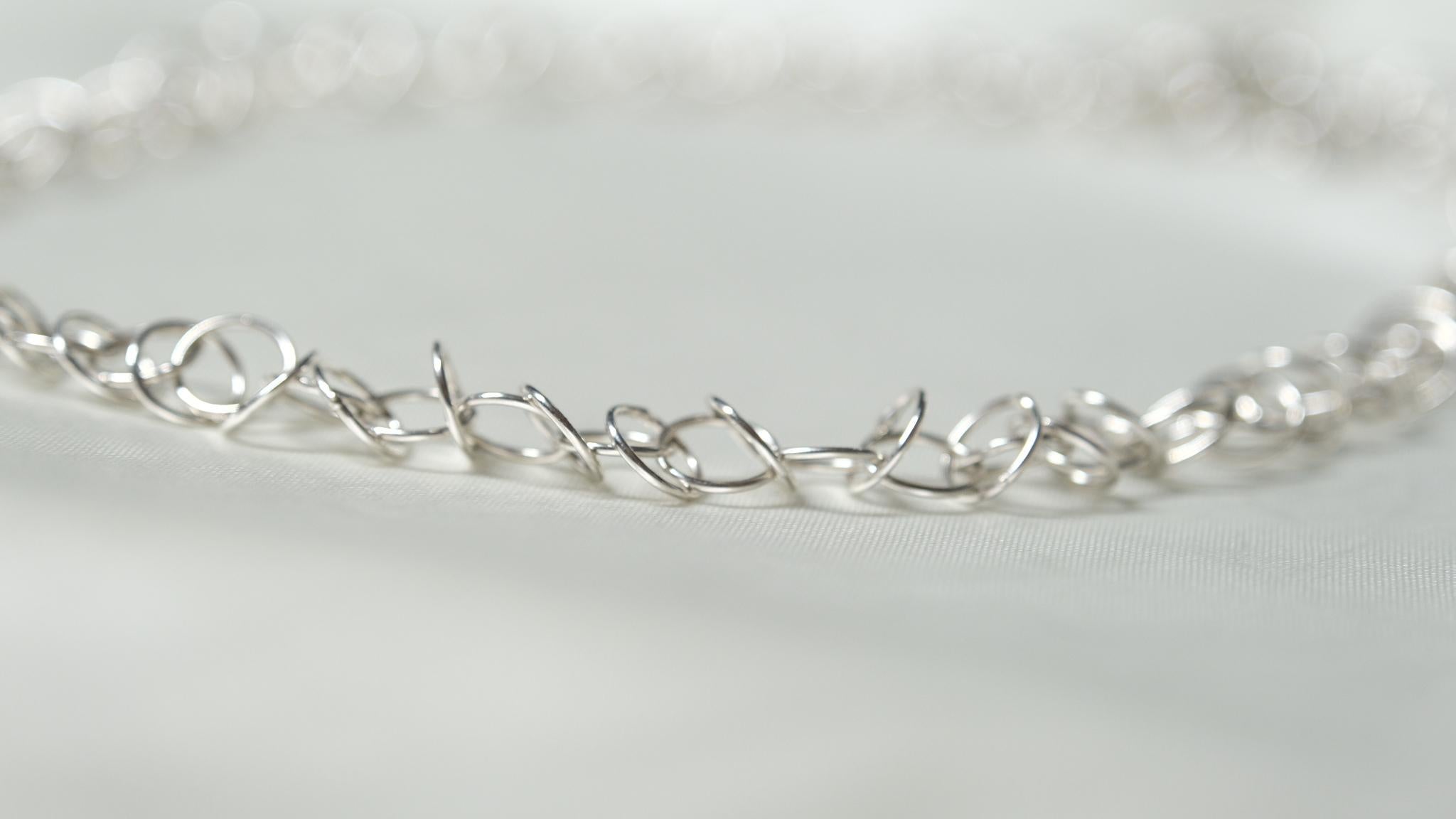 Einzelheiten zum Produkt:

Die Loop-Kette ist eine handgefertigte Perfektion aus kostbaren, metallischen, kreisförmigen Schleifen, die miteinander verbunden sind, um ein wunderschönes Schmuckstück zu schaffen. Offiziell gestempelt im Assay Office,