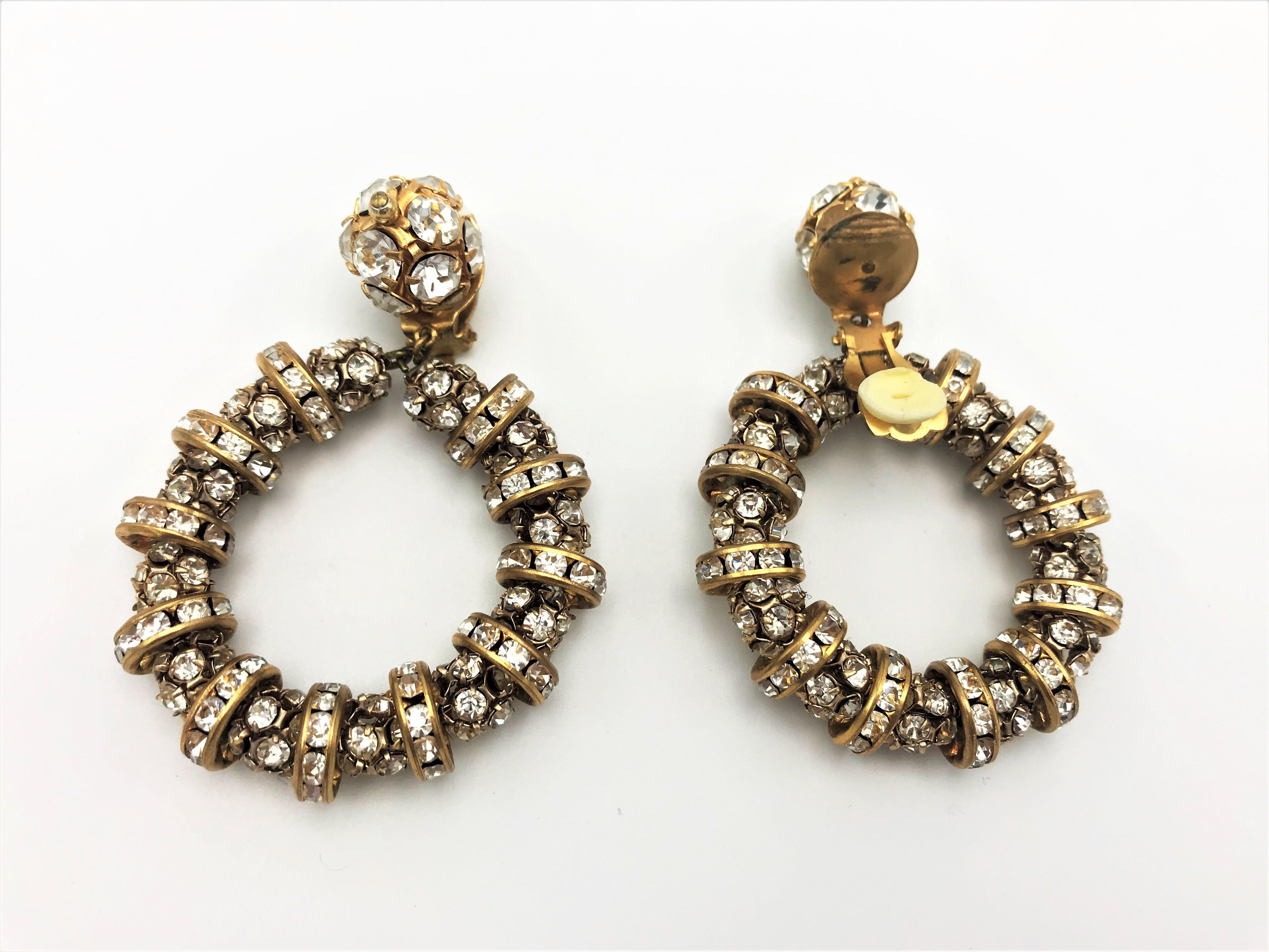 Beautiful stylish ear clips consisting of movable rhinestone balls and rhinestone circles. Each rhinestone is set individually. Likewise the ball with the well-functioning clip. There is a wonderful gold-silver look! Probably made by  Valentino