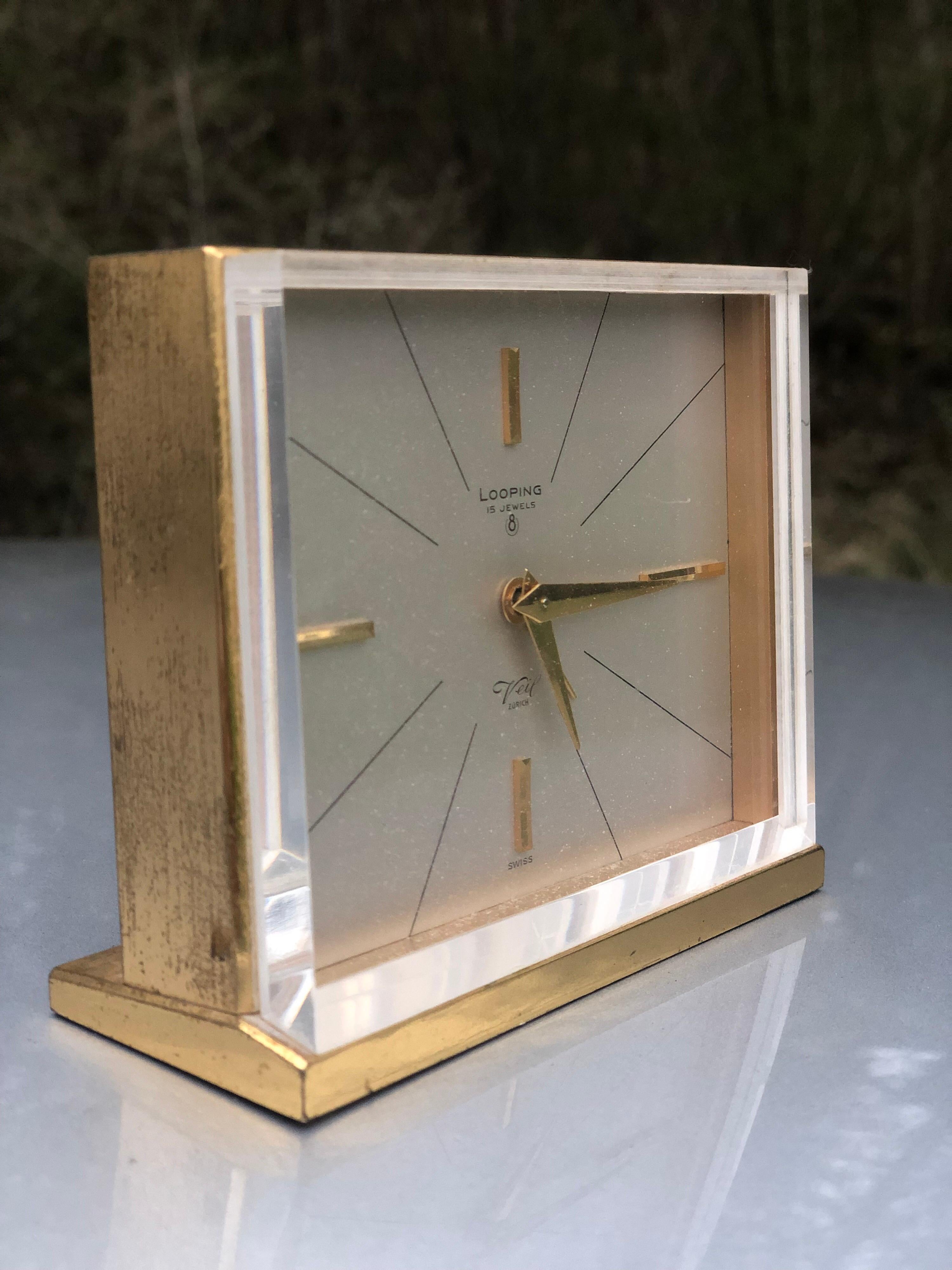 Swiss desk clock marked Looping: Eight day alarm clock in a polished brass case, 15 jewel works, dial marked Made in Switzerland.
 