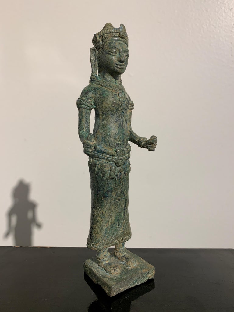 A charming and unusual cast bronze figure of the Hindu goddess Uma, Lopburi Style, 13th-14th century, Thailand.

Uma, the Hindu goddess of love and beauty, also known as Parvati, is the consort of Shiva. She is portrayed here with somewhat