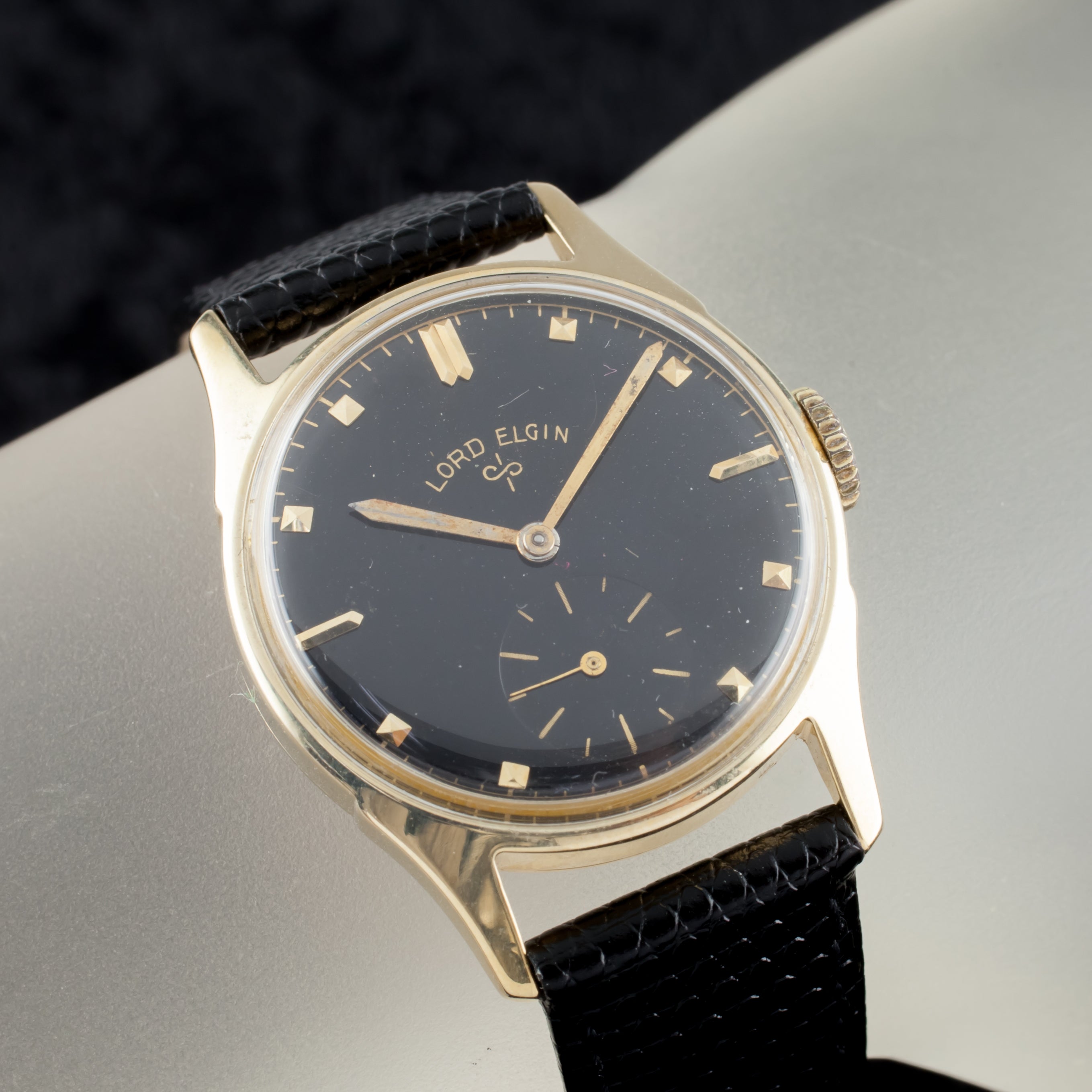 Reloj de cuerda manual vintage Lord Elgin de oro amarillo de 14 quilates Esfera negra 1953
Caso nº 4902
Número de serie 496881
Movimiento nº 556
Número de serie del movimiento F436722

Caja de oro amarillo de 14k
28 mm de diámetro (30 mm con