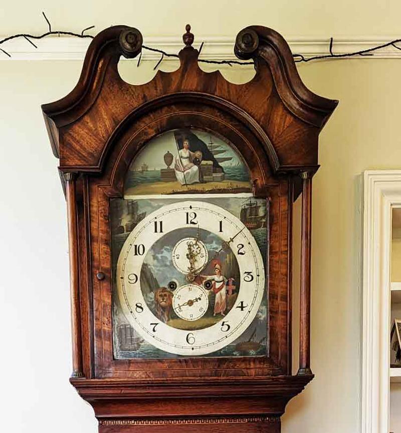 This Georgian Mahogany longcase clock was made in the Georgian period of about 1815. 

It is a chiming 8 day clock with golden feathered grain. It has an inlaid and crossbanded decoration. 

It measures approximately 22 inches wide by 10 inches deep