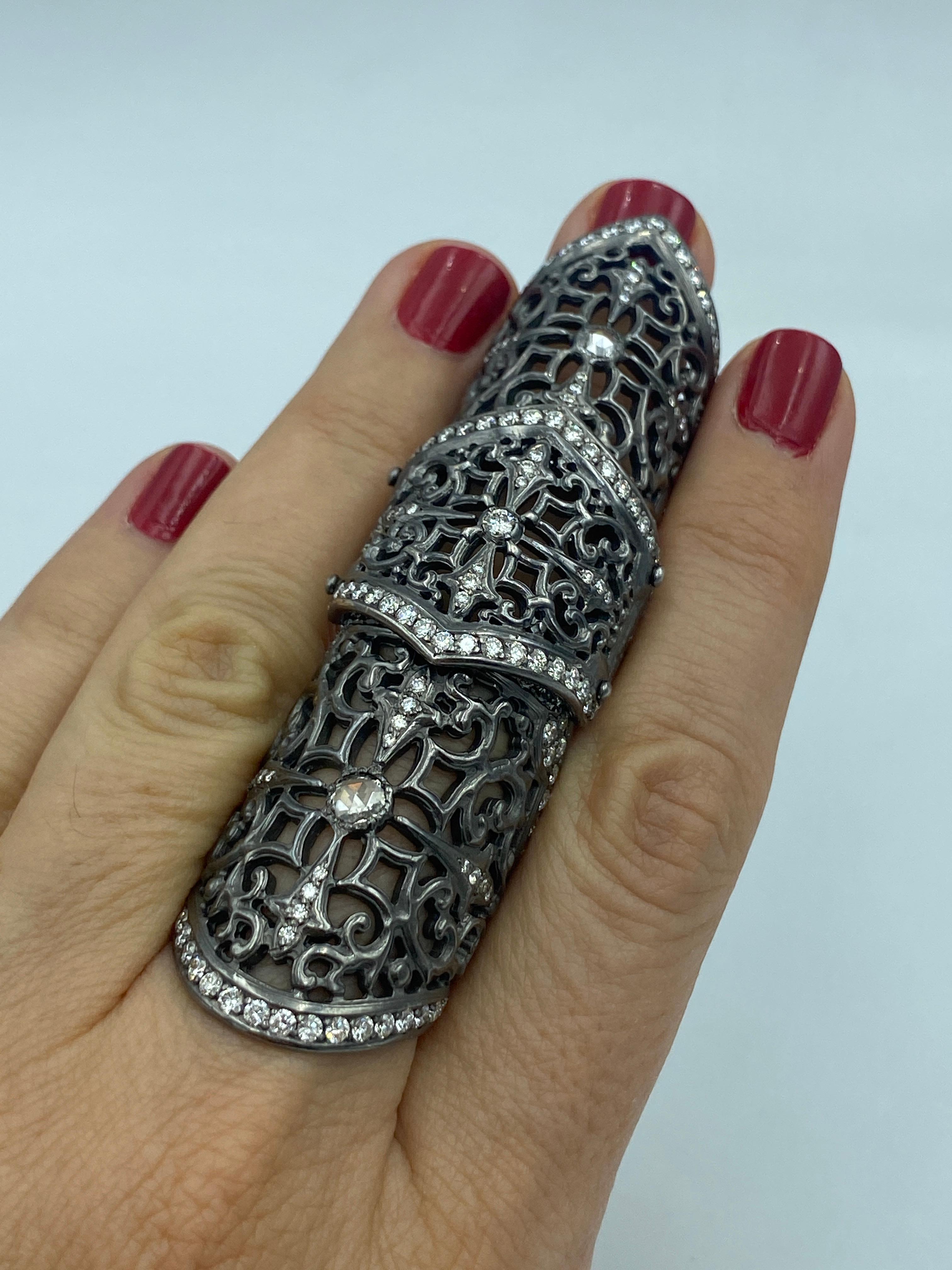 This 18k gold and diamond knuckle ring by Loree Rodkin is 8cm in length and is comprised of 3 hinged sections. It sits comfortably on the finger and easily allows for movement. The intricate laticework is outlined with round cut diamonds. Each