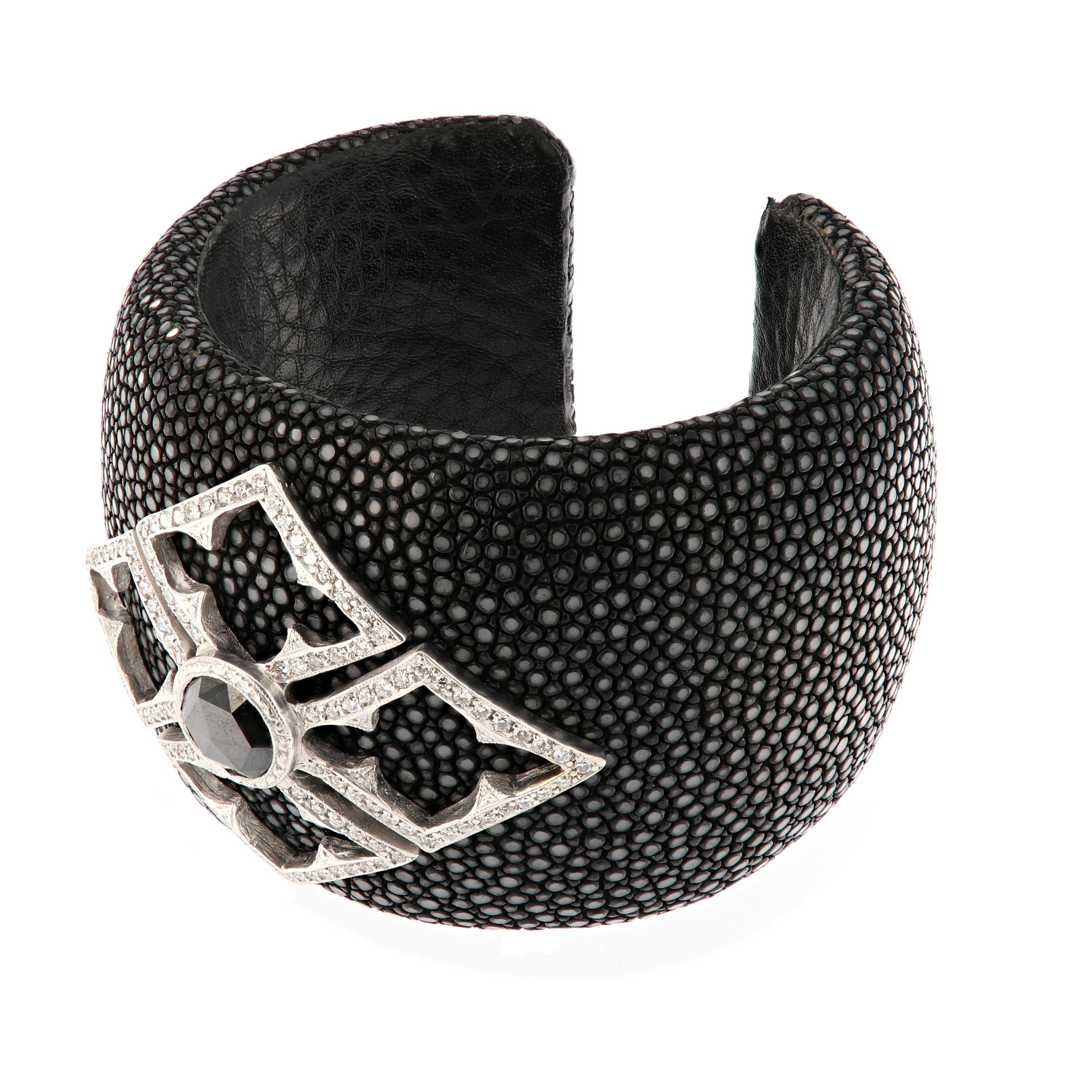 Loree Rodkin statement bracelet is a large shagreen cuff with large pave Berber cross applique made in 18k white gold, pave set with full-cut round diamonds. Bezel set in the center is a 5.11 carat round faceted black diamond. This estate piece is