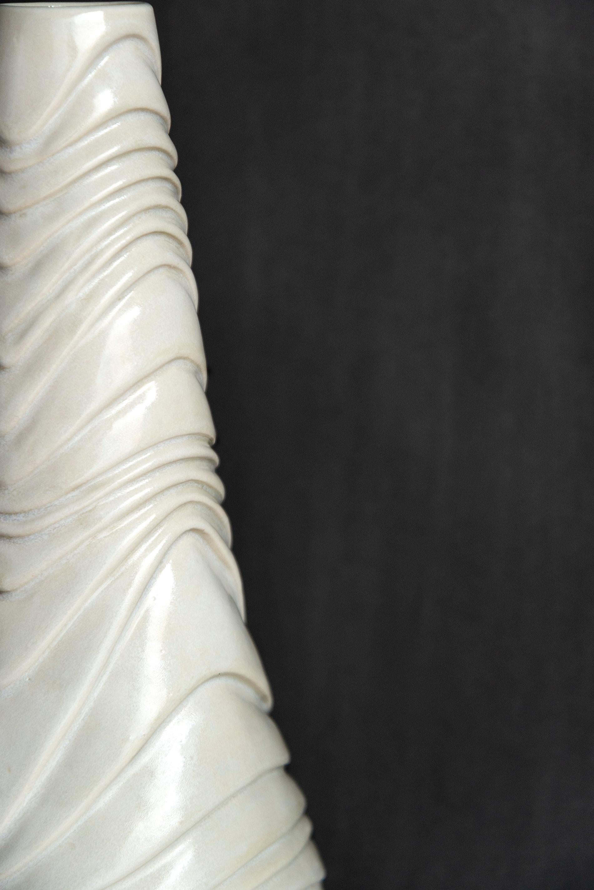 This contemporary white ceramic vessel is handmade.

Loren Kaplan creates uniquely beautiful ceramics. Her elegant forms are inspired by nature; each design has found the sweet spot between traditional, historical, and modern styles. This tall
