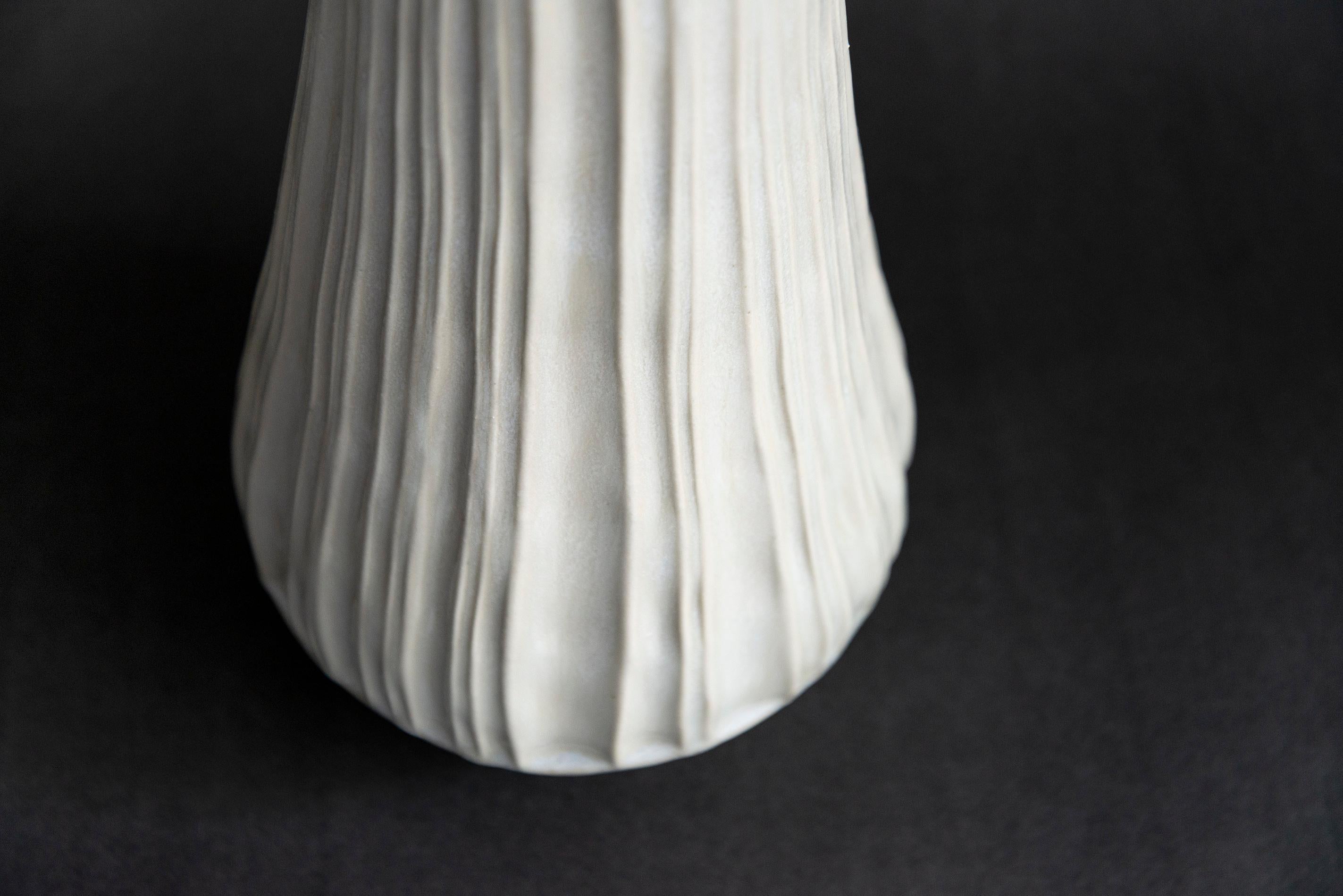 This contemporary white ceramic vessel is handmade.

Loren Kaplan creates uniquely beautiful ceramics. Her elegant forms are inspired by nature; each design has found the sweet spot between traditional, historical and modern style. This tall