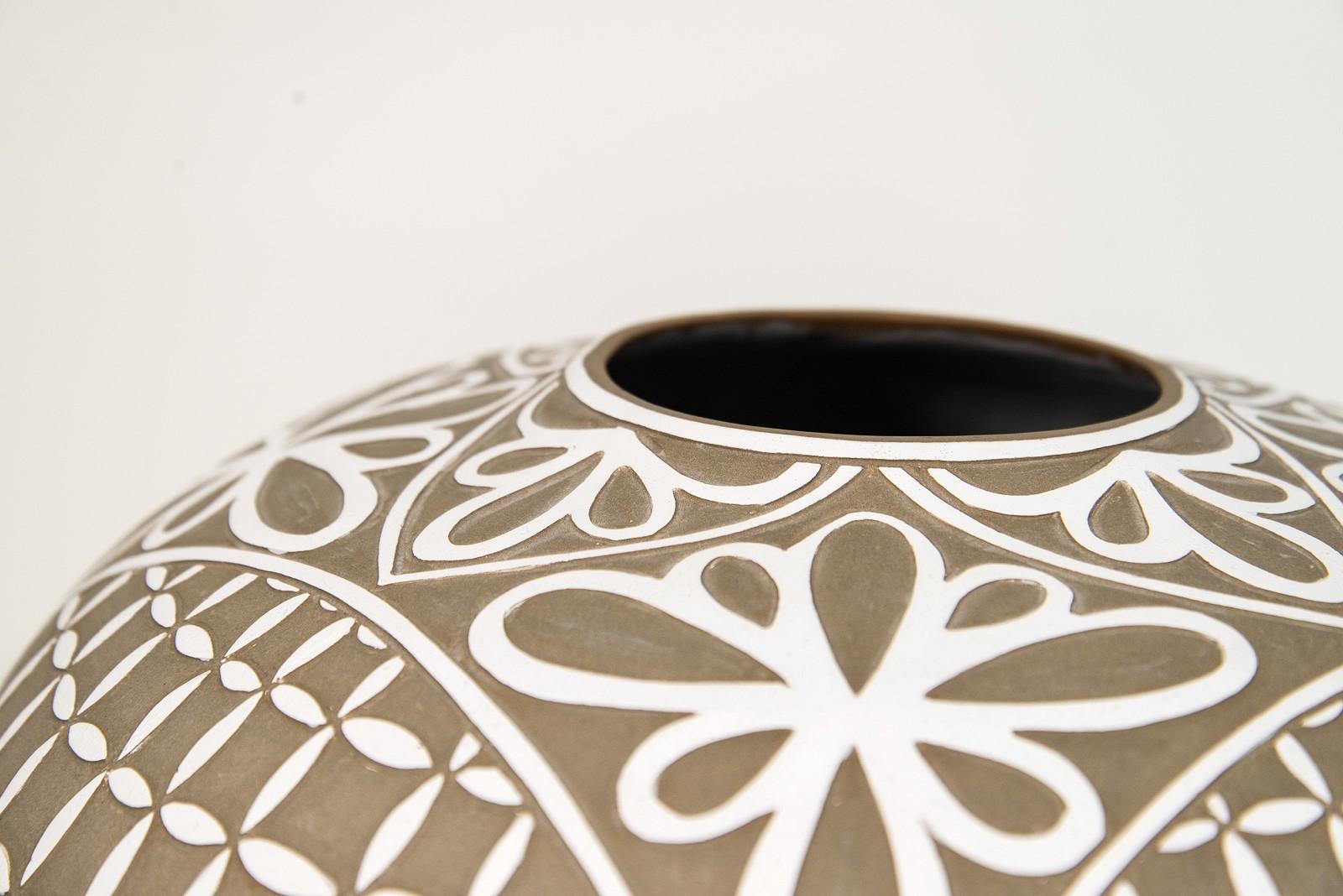 Dieses elegante Gefäß der Keramikerin Loren Kaplan ist mit zarten Blumenblättern verziert. Seine klassische Form wird durch die neutrale taupefarbene Farbe und das kontrastreiche, strahlende Weiß der handgravierten Blütenblätter noch verstärkt.