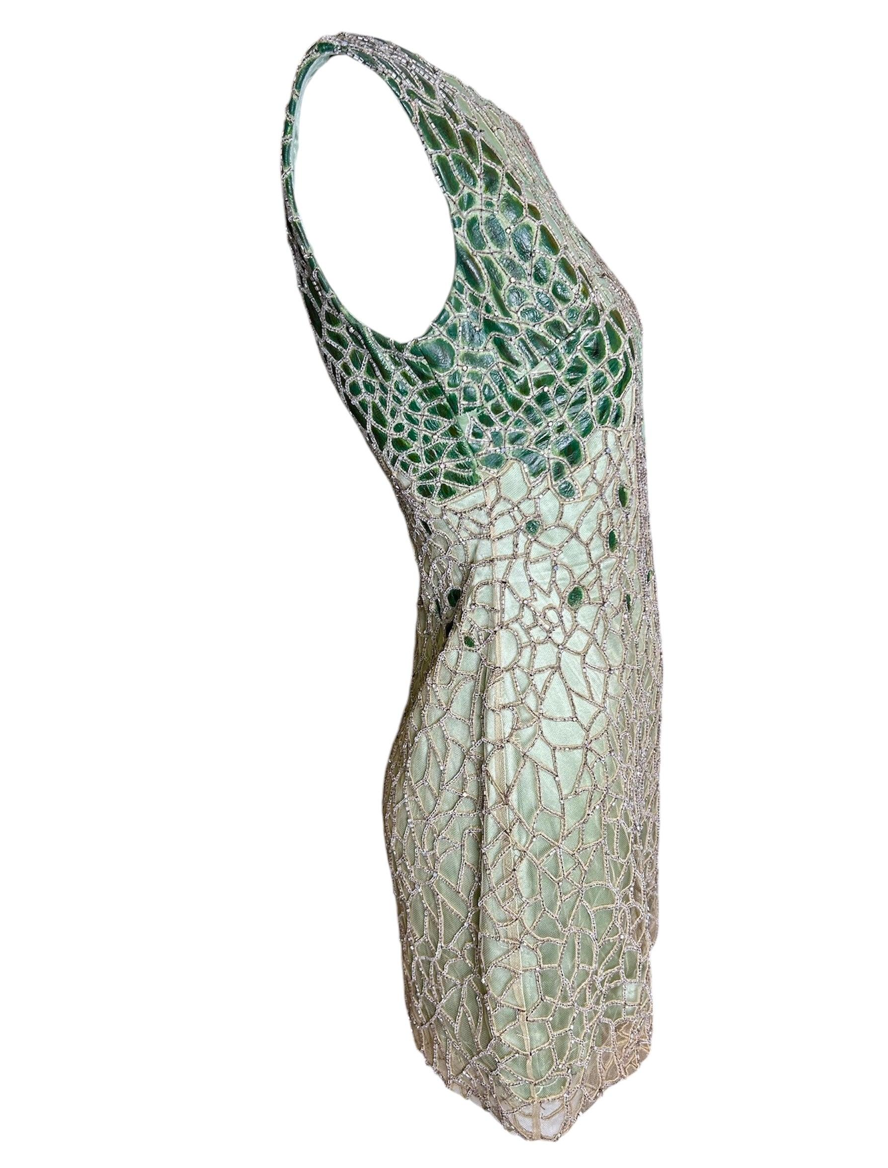 This stunning Lorena Sarbu dress is serpentine sex-appeal in a modern setting. Immaculately beaded in scaling and accented with leather patchwork, this dress speaks for craftsmanship as much as appeal. Various hues of green mosaic throughout like a