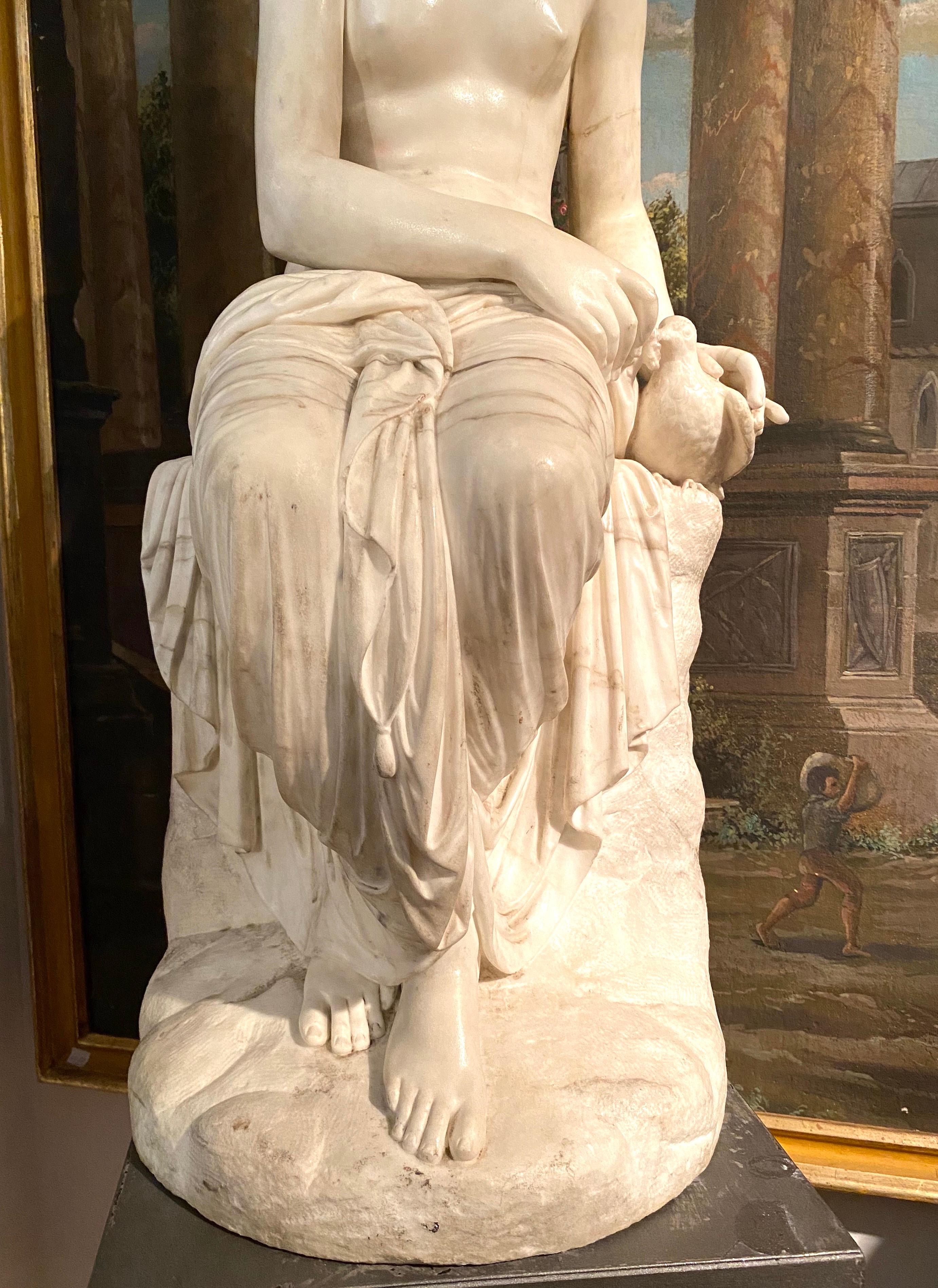 Delicious Neoclassical White Marble Sculpture of Seated Nymph feeding a dove . 
 The Neoclassical composition also incorporates drapery which is used to conceal her nudity.  The turn of the neck, but leans slightly forward, adding greater finesse to
