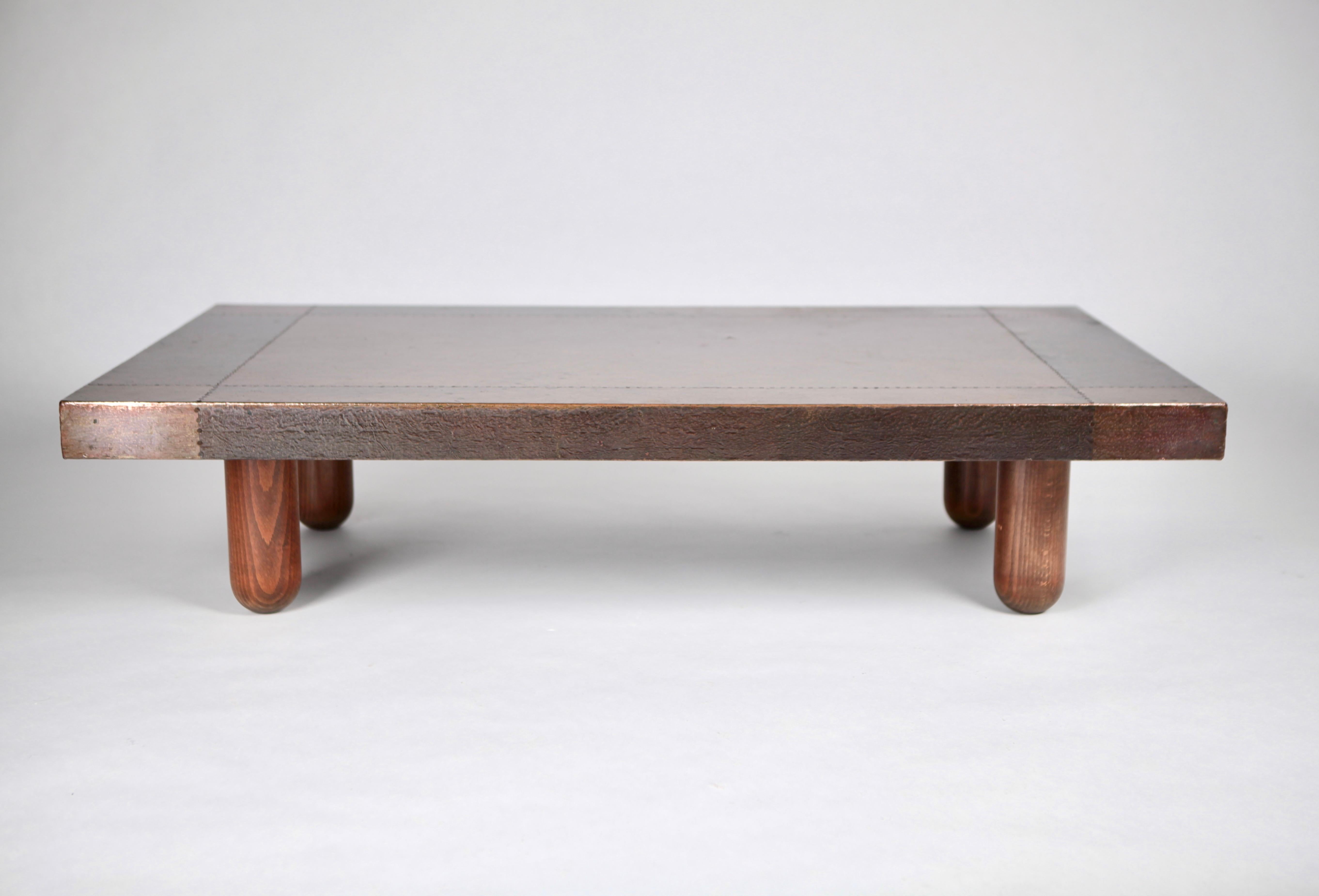 This outstanding and unique coffee-table by Italian designer & sculptor Lorenzo Burchiellaro (1933-) is a real catching anchor piece. It is executed in copper with nail trimming & stained oak legs.
The copper surface with a fantastic