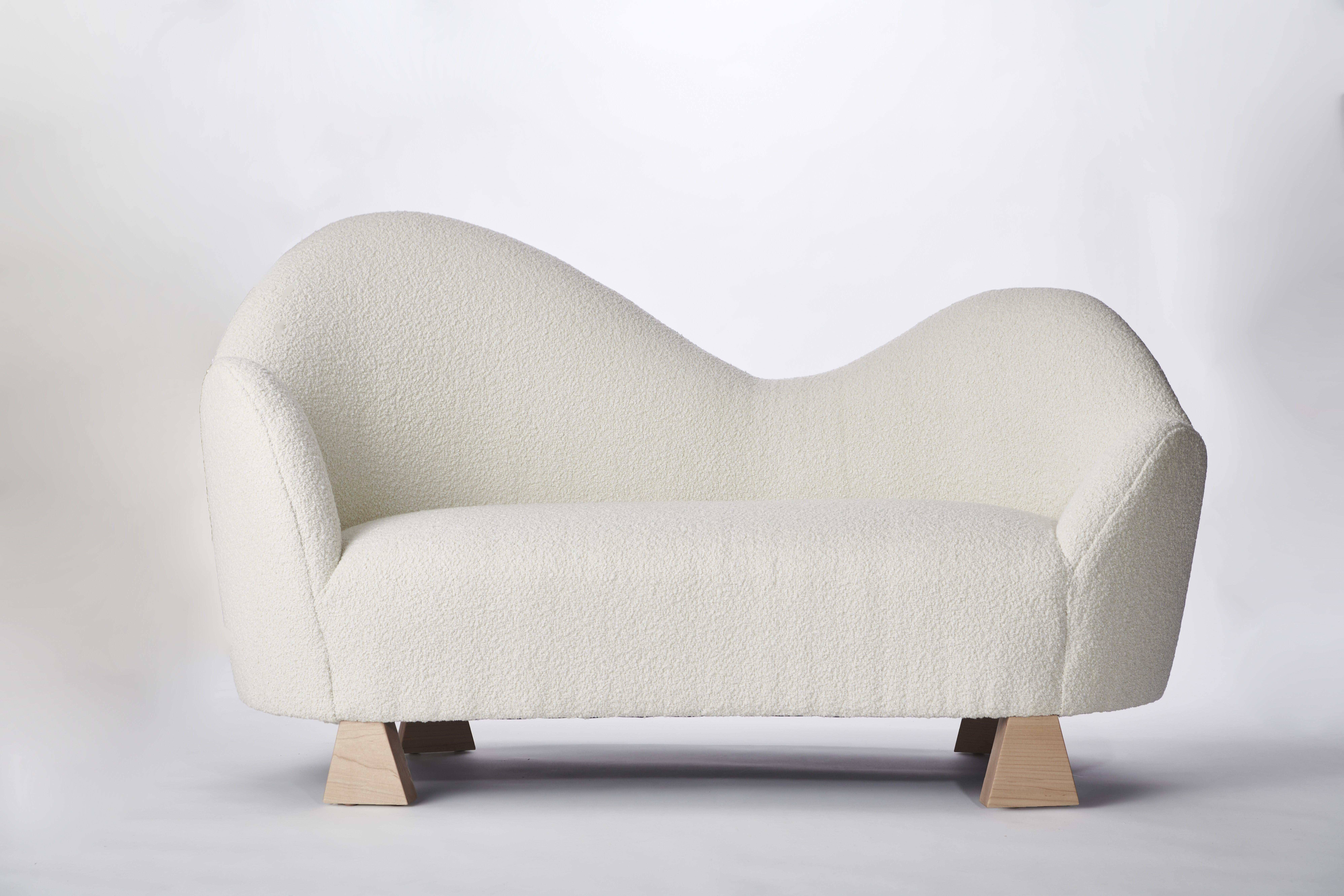 Made to order bouclé and wood settee designed by Christian Siriano.

Fabric: Ivory bouclé (available in custom fabric)
Base: Natural Maple (available in custom finish)
 
Dimensions: 
Overall Width: 64”
Overall Depth: 30” 
Overall Height: 41”
Seat